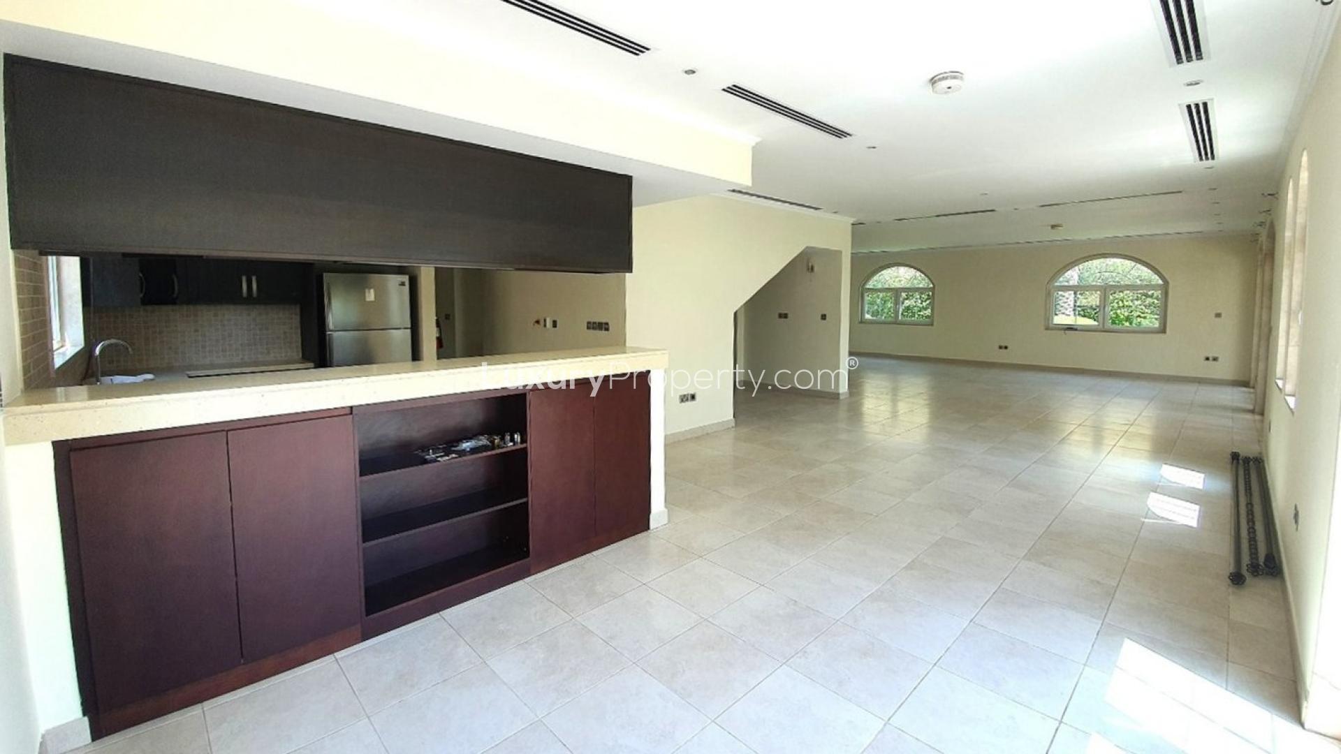 Elegant living area in 5-bedroom villa, Legacy, Jumeirah Park, featuring arched windows and kitchenette