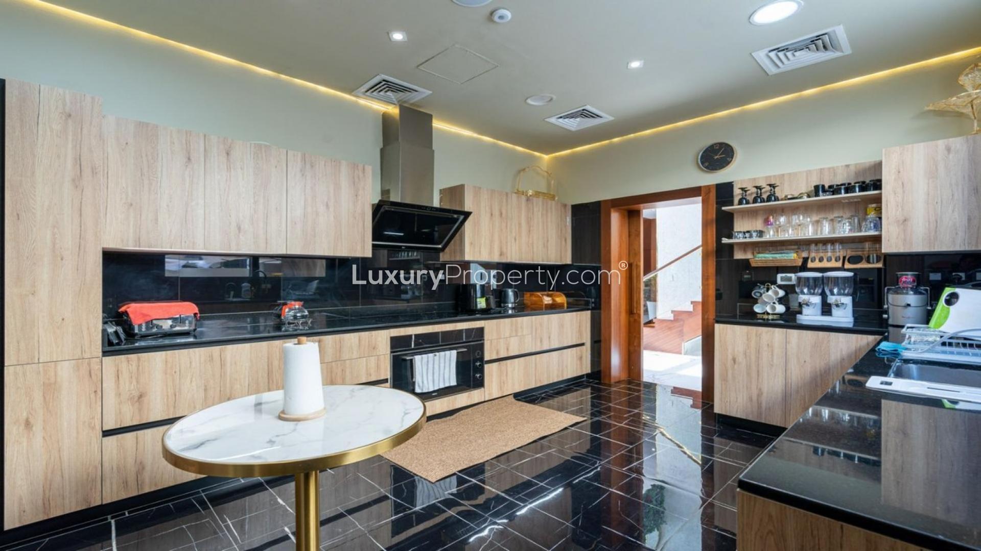 Modern kitchen in upgraded Whitefield villa, Damac Hills, featuring sleek wood cabinetry and appliances