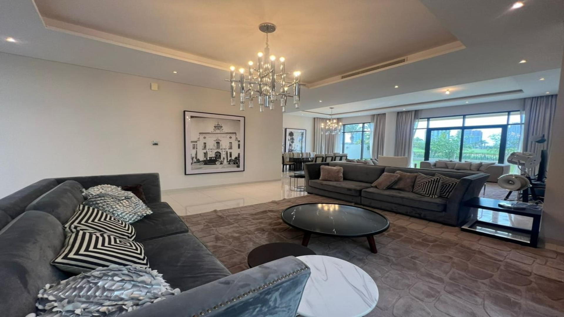 Alt text: "Scenic view from villa in Damac Hills, The Turf, overlooking landscaped garden and golf course.",Luxurious furnished living room in 5-bedroom villa, Damac Hills, The Turf, for rent