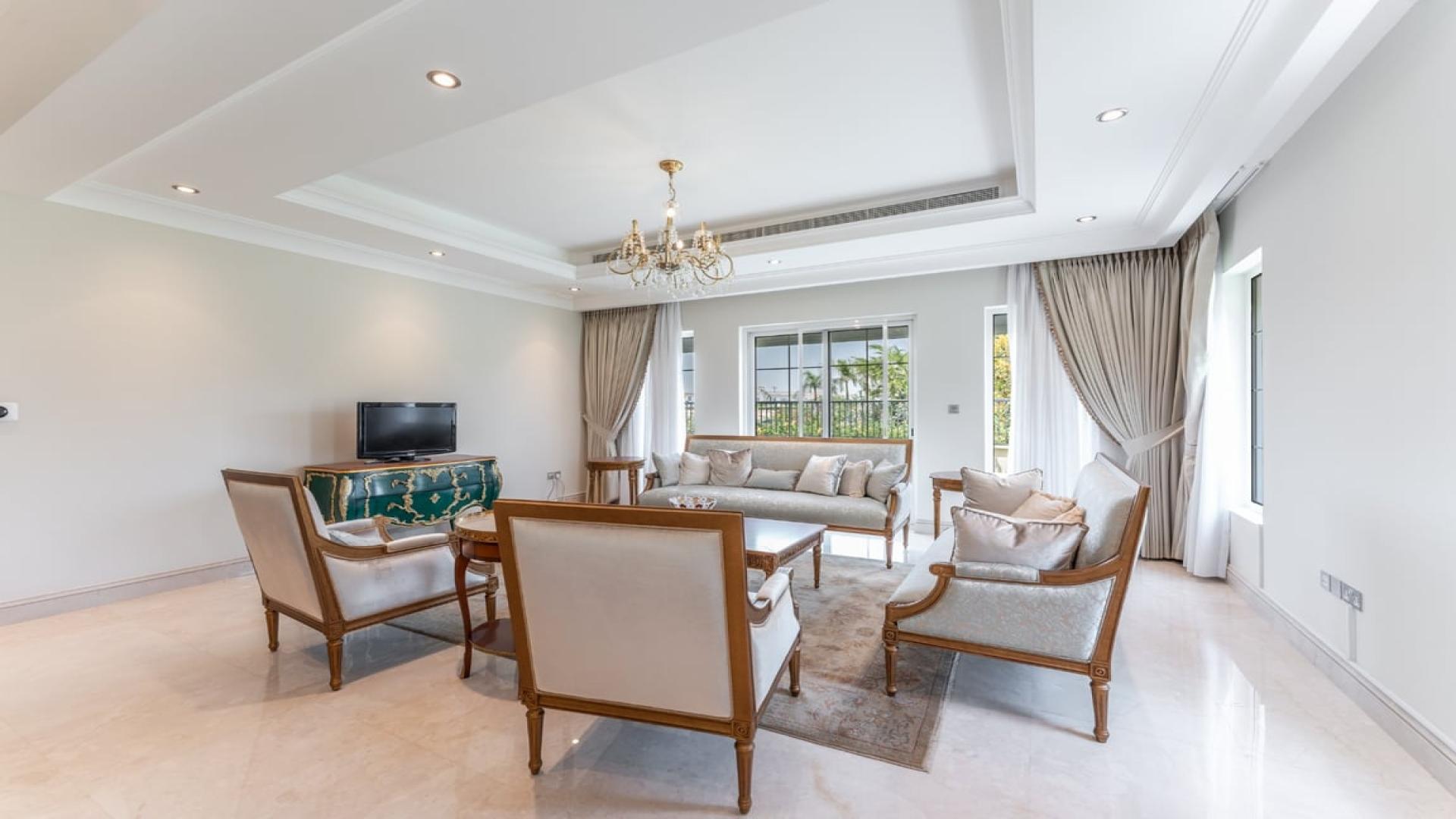 Elegant living room in La Avenida villa, Arabian Ranches, featuring classic furnishings and chandeliers