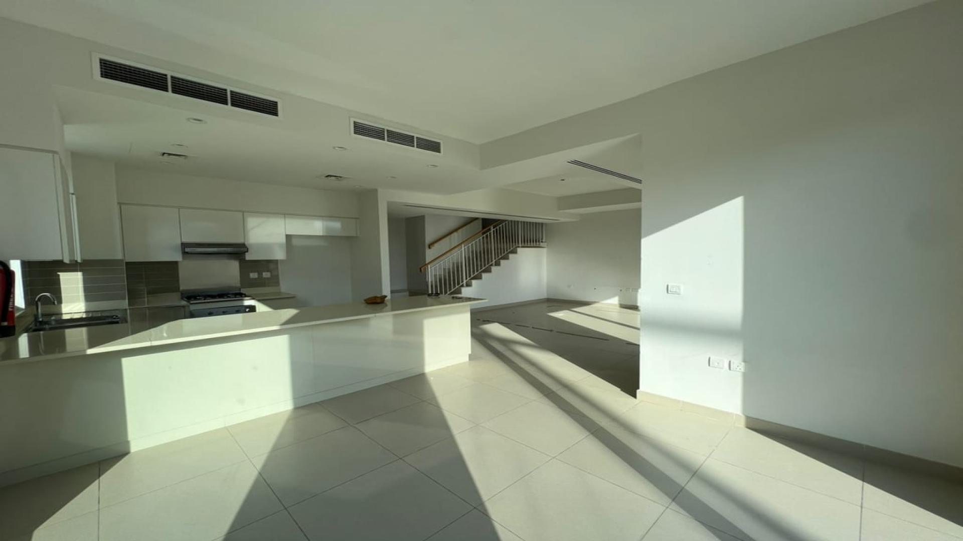Modern kitchen and living area in a vacant 5-bedroom villa, Dubai Hills Estate