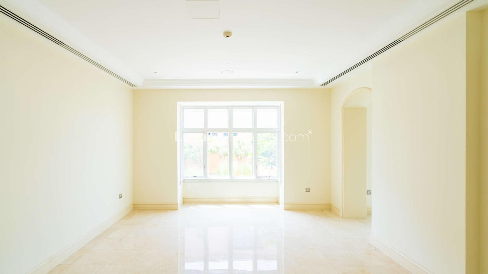 Spacious living room in five-bedroom villa, Jumeirah Golf Estates, bright windows, neutral decor