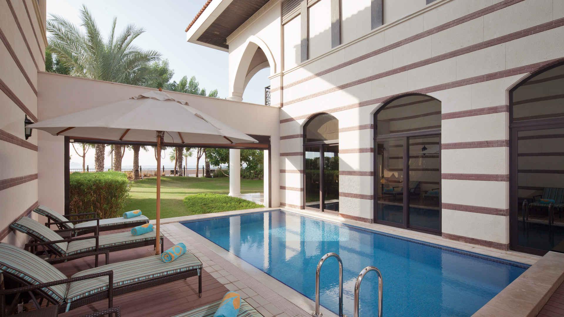 Luxurious villa garden view with palm trees, overlooking Dubai skyline in Jumeirah Zabeel Saray
