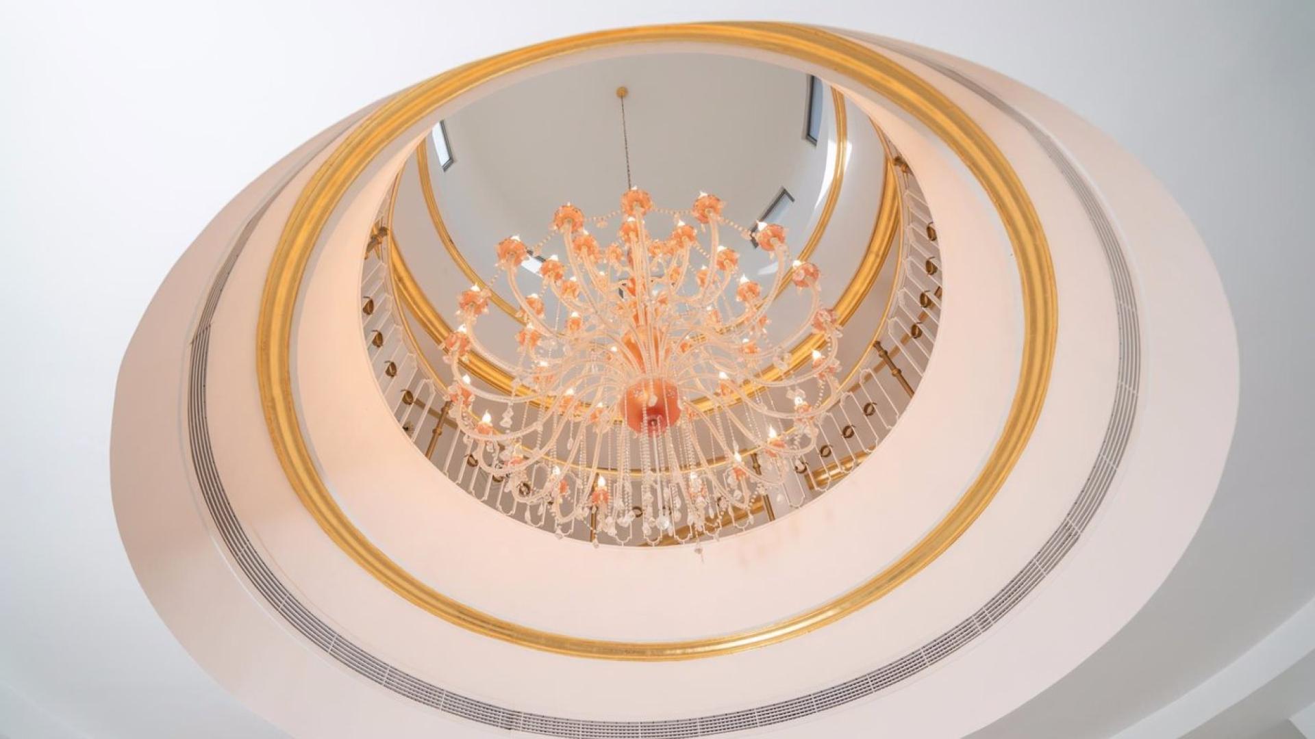 "Elegant entrance of five-bedroom villa on Palm Jumeirah, showcasing luxurious interior design.",Elegant chandelier in luxurious Palm Jumeirah Signature Villa, five-bedroom classic style residence