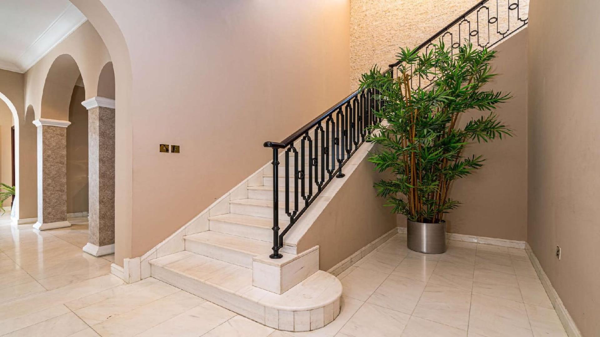 "Elegant Palm Jumeirah villa exterior with lush landscaping and grand entrance steps.",Elegant marble staircase in Palm Jumeirah Signature Villa, LP03540, with lush indoor plant