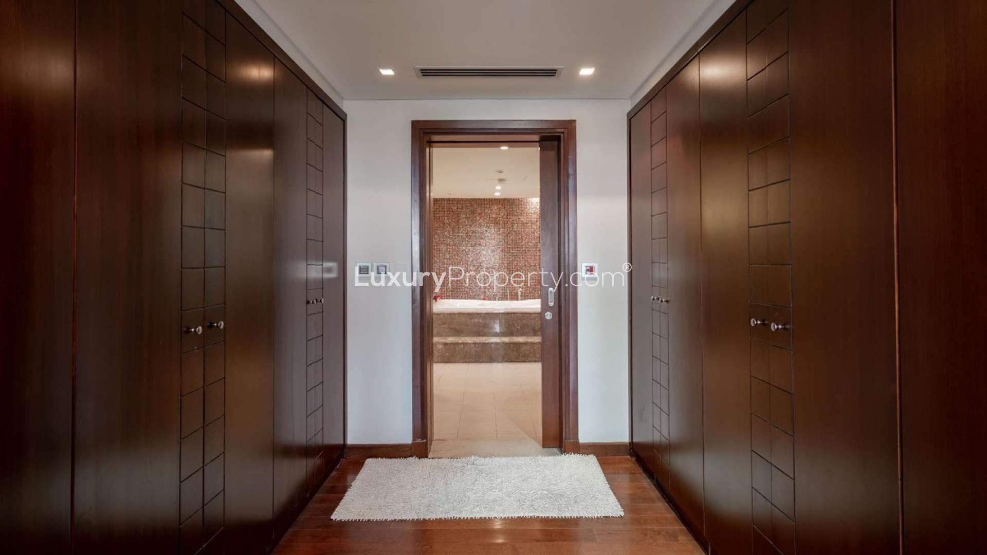 Luxurious walk-in closet leading to bathroom in Jumeirah Islands mansion villa for sale