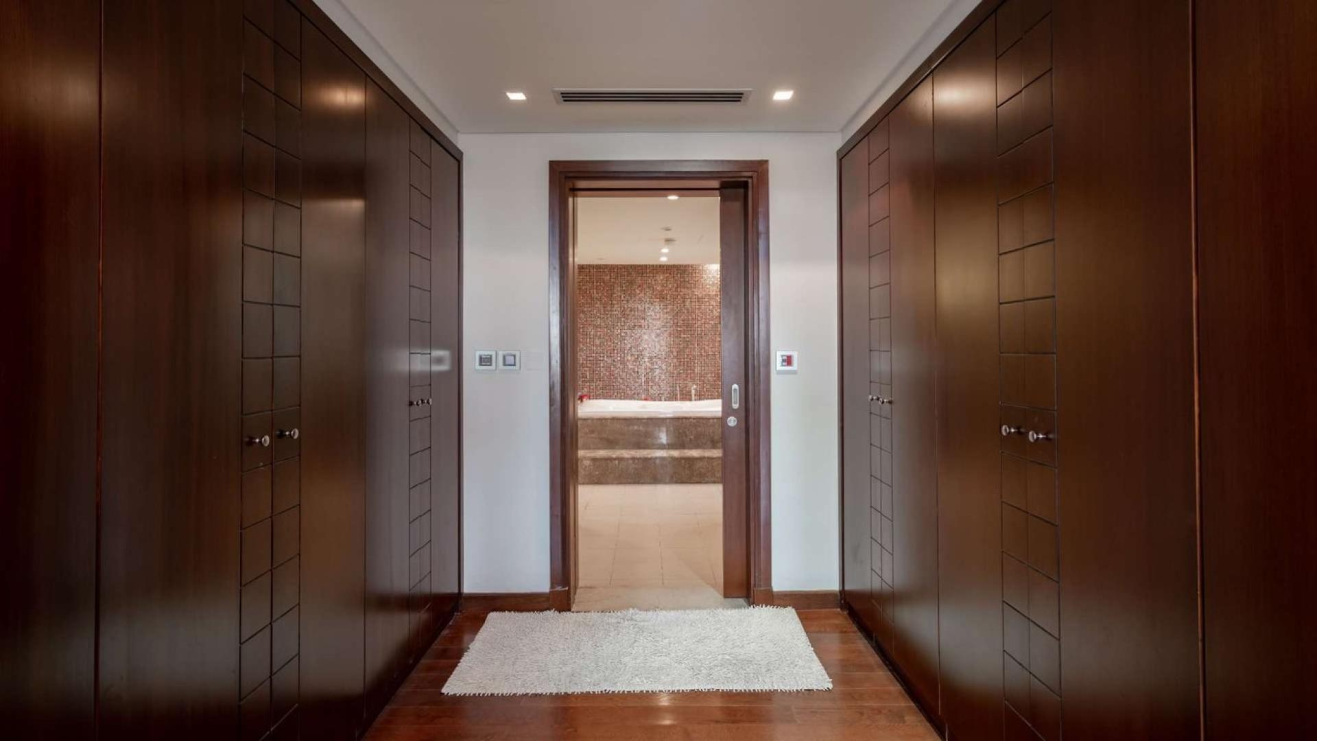 Luxurious walk-in closet leading to bathroom in Jumeirah Islands mansion villa for sale