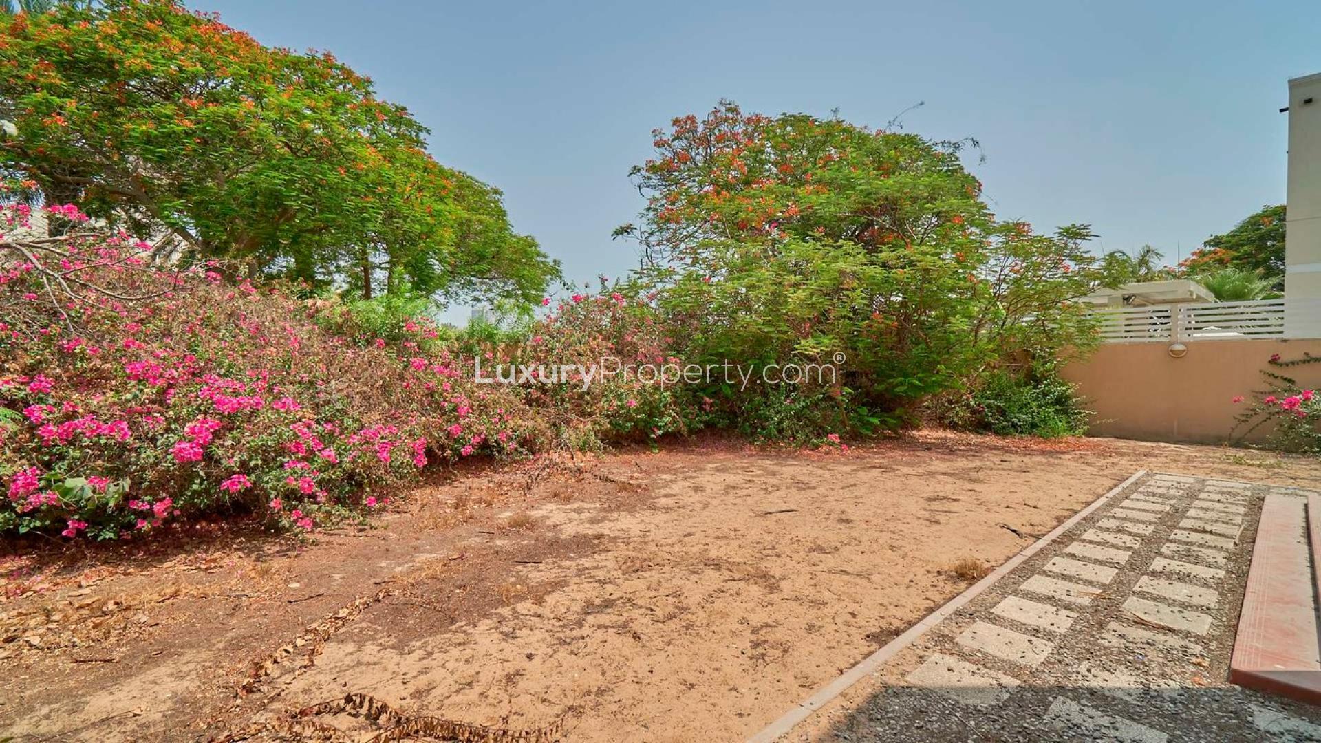 Five-bedroom villa exterior in Meadows 5, Emirates Living, with two cars in driveway