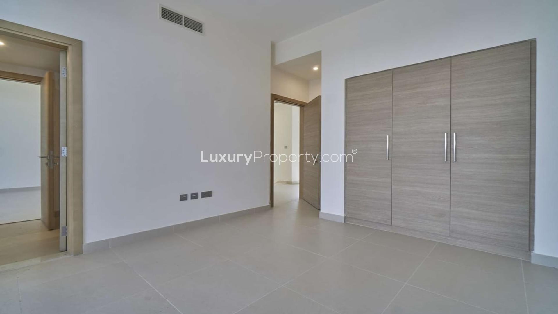 "Modern 5-bedroom villa exterior in Sidra, Dubai Hills Estate, for sale, street view.",Empty bedroom with built-in wardrobe in Sidra Villas, Dubai Hills Estate villa for sale