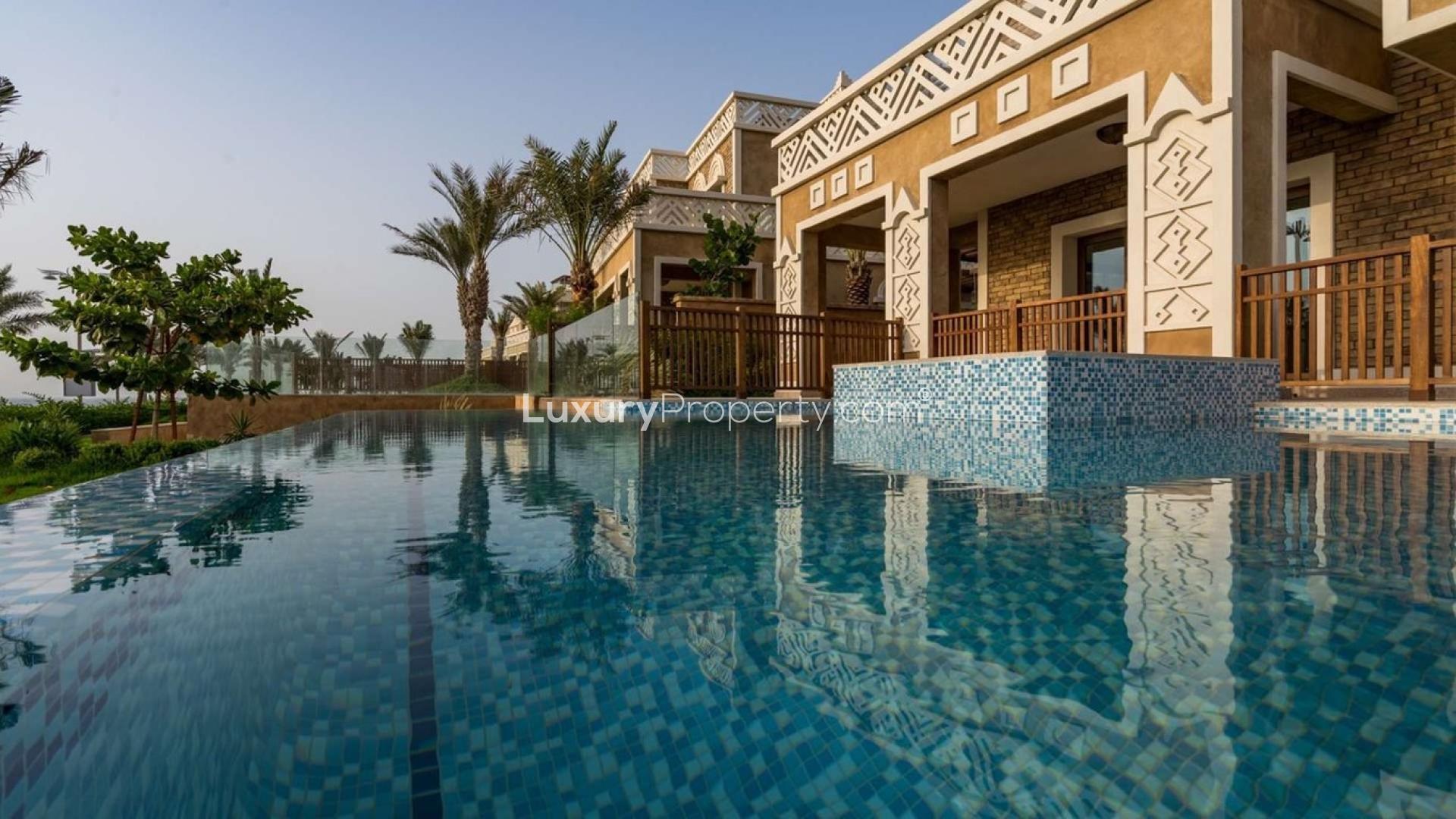 "Majestic villa terrace view of sunset over pool, Palm Jumeirah, Kingdom of Sheba.","Majestic villa with stunning pool view in Kingdom of Sheba, Palm Jumeirah, for sale.",Spacious living area with large windows and ocean view in Palm Jumeirah villa