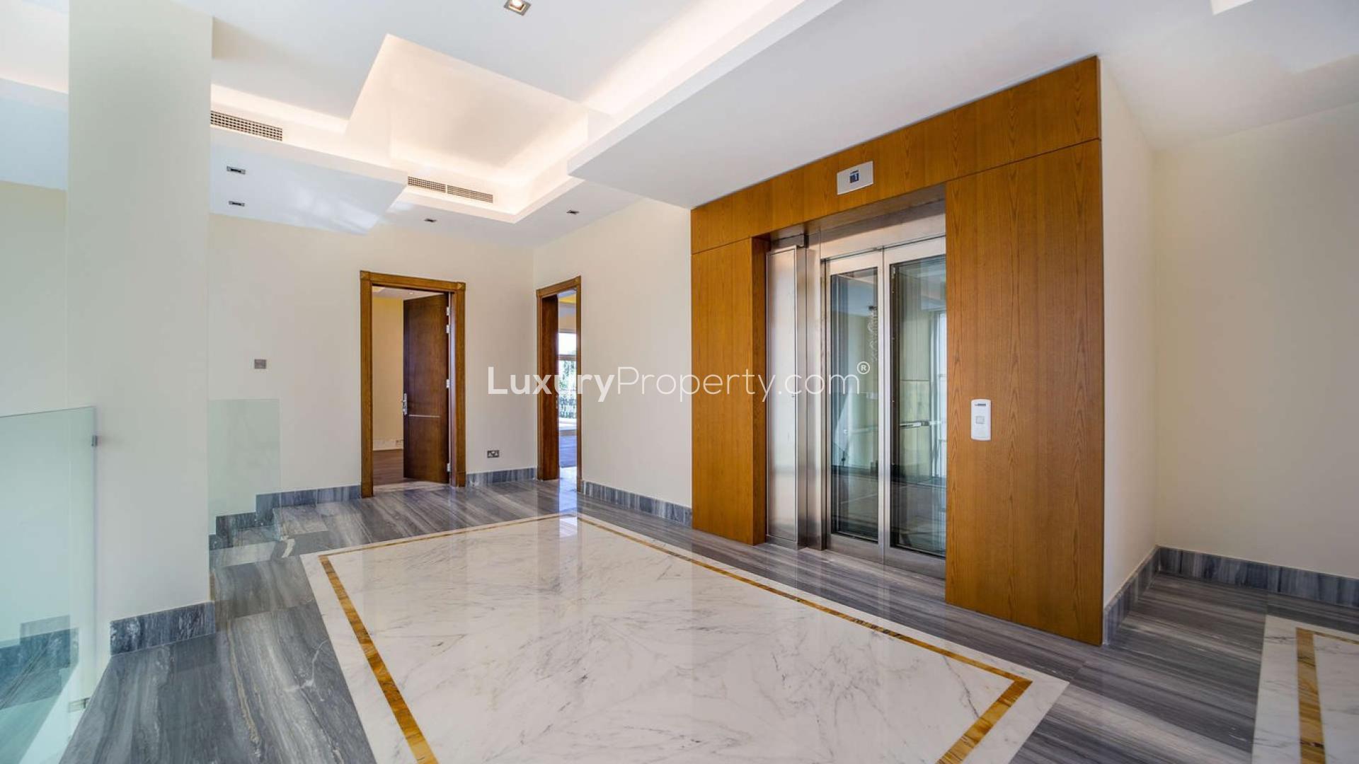 Luxury villa interior with marble flooring, large windows, and wooden ceiling in JGE Earth