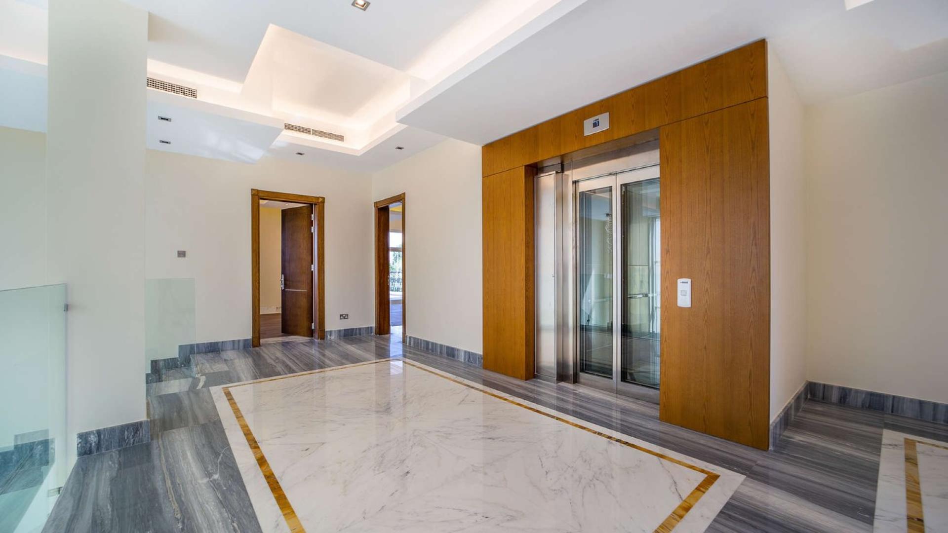 Luxury villa interior with marble flooring, large windows, and wooden ceiling in JGE Earth