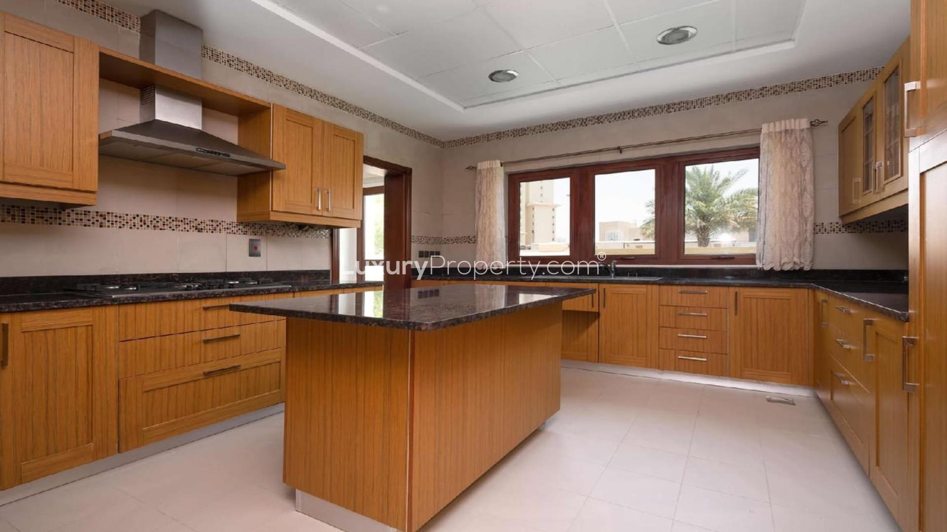 Spacious kitchen with wooden cabinets in Jumeirah Golf Estates villa for sale