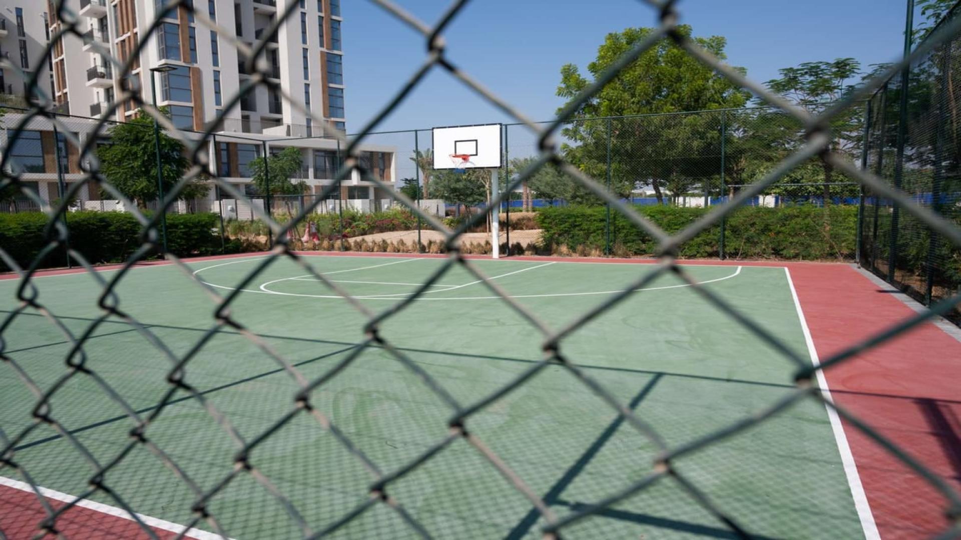 "Balcony view from spacious 4-bedroom townhouse in Al Salam, Mudon, Dubai, lush greenery visible.",Spacious townhouse interior with staircase and kitchen view in Al Salam, Mudon, Dubai