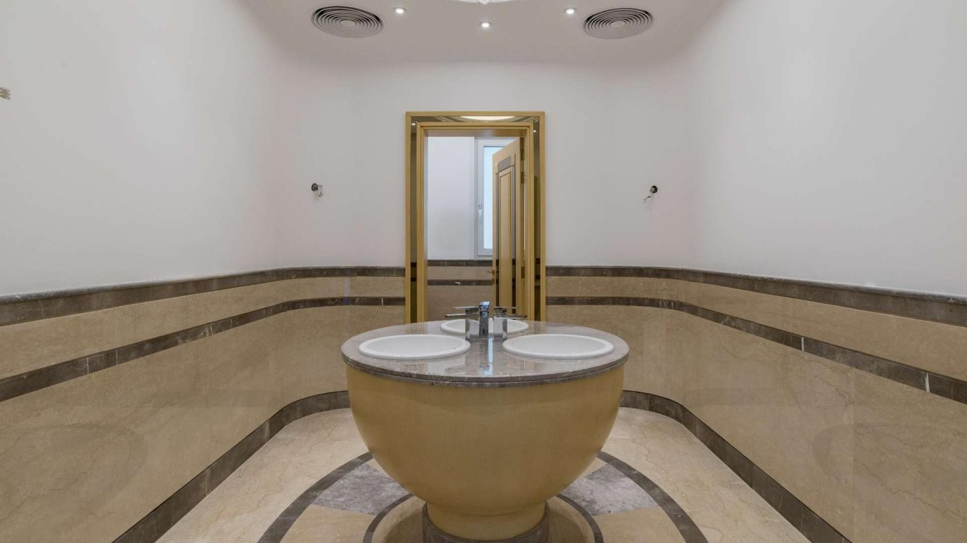 "Elegant villa entrance with grand staircase, large windows, and luxurious architectural details.",Luxurious villa bathroom with double sink and elegant marble finishes for sale