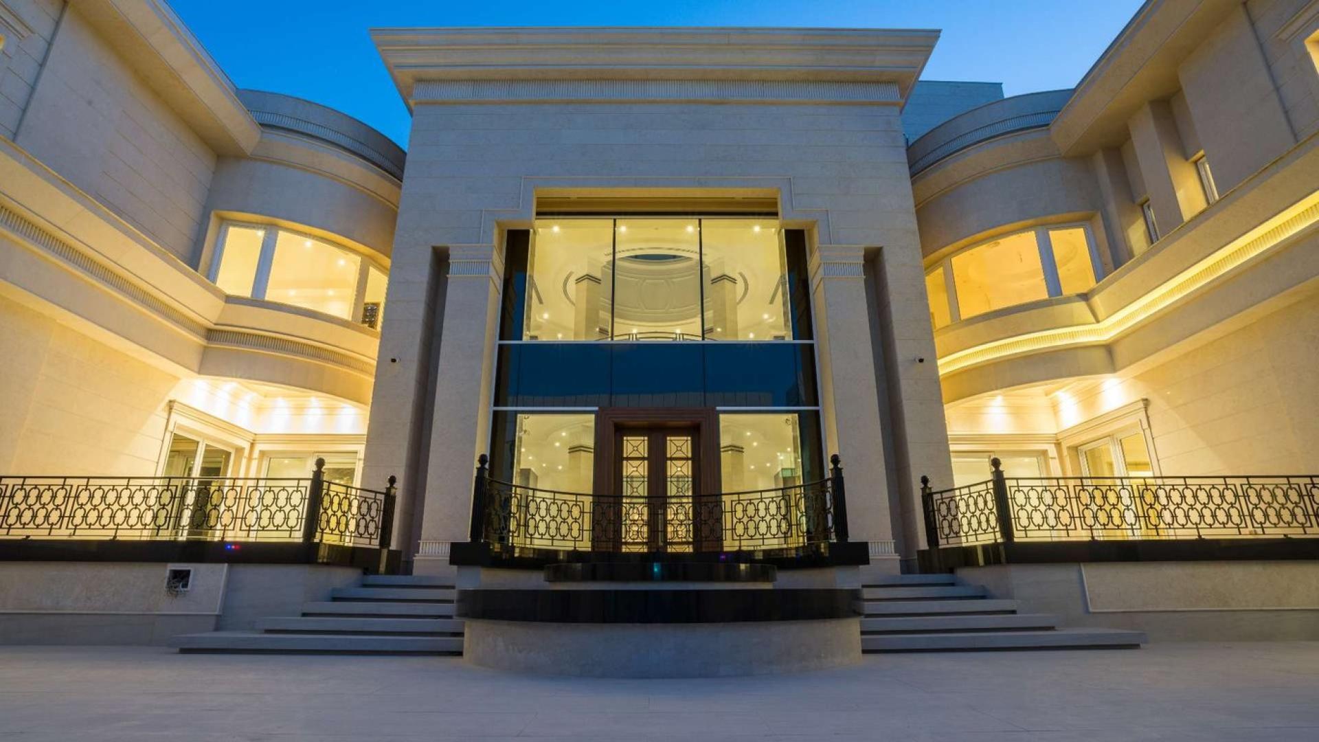 Luxurious villa exterior at dusk, featuring elegant lighting and modern architecture, for sale