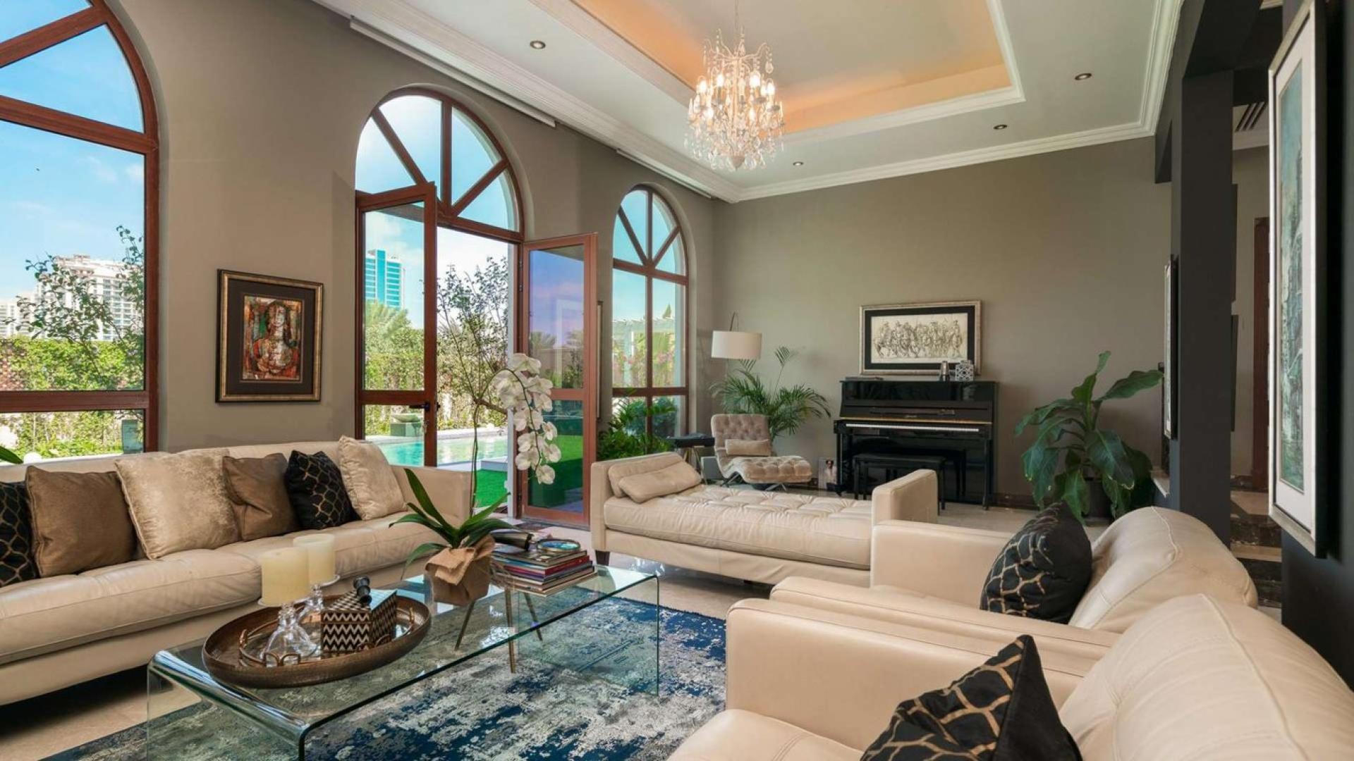 Luxurious living room in upgraded Jumeirah Golf Estates villa with elegant decor and garden view