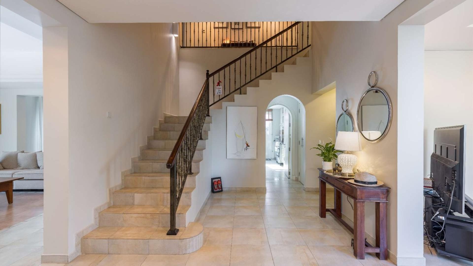 Living room in 5-bed villa, Victory Heights, Dubai Sports City, with elegant decor and pool view