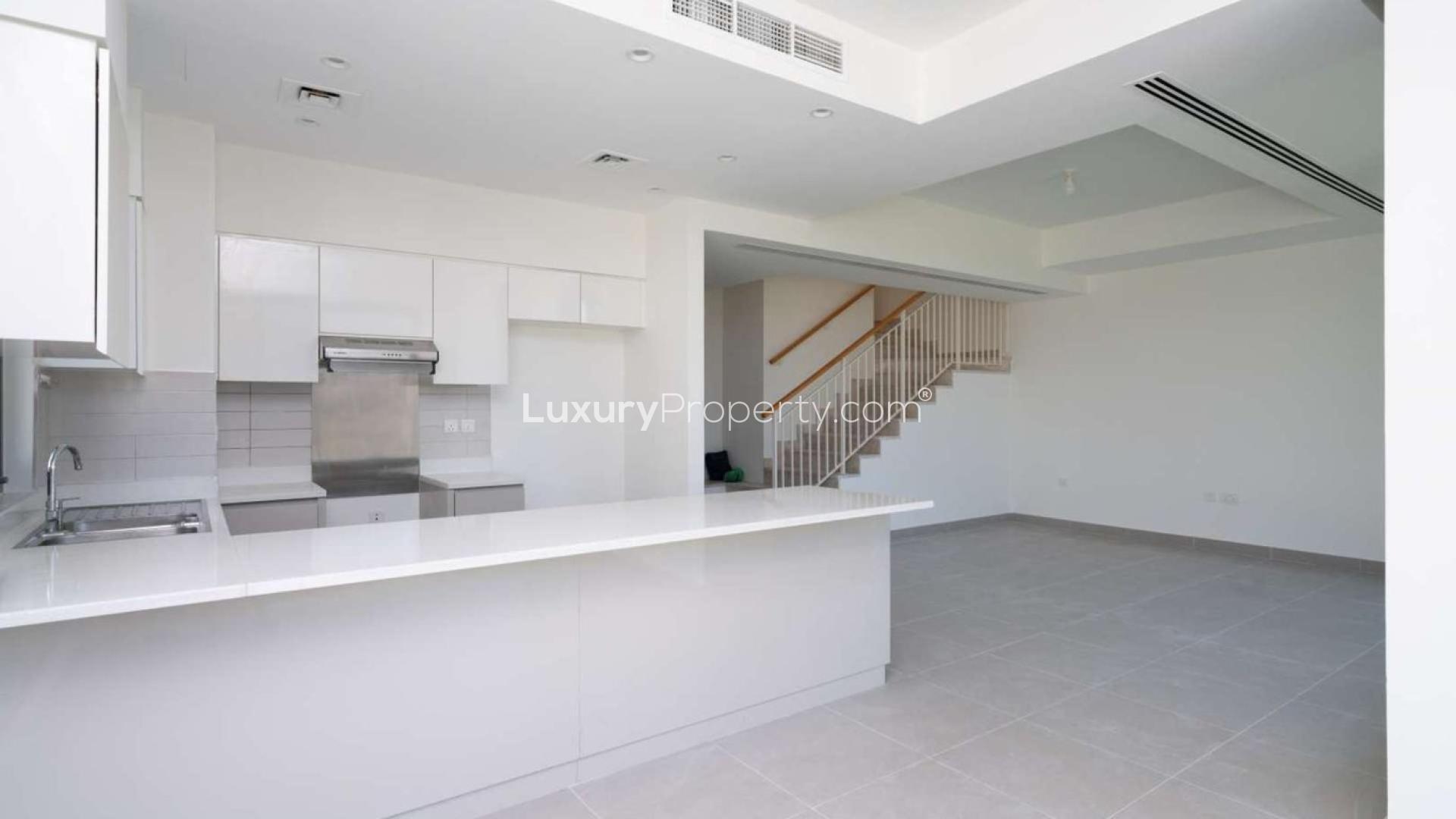 "Spacious garden view of 5-bedroom villa in Maple 2, Dubai Hills Estate for sale.",Modern kitchen and open living space in Maple 2 villa, Dubai Hills Estate