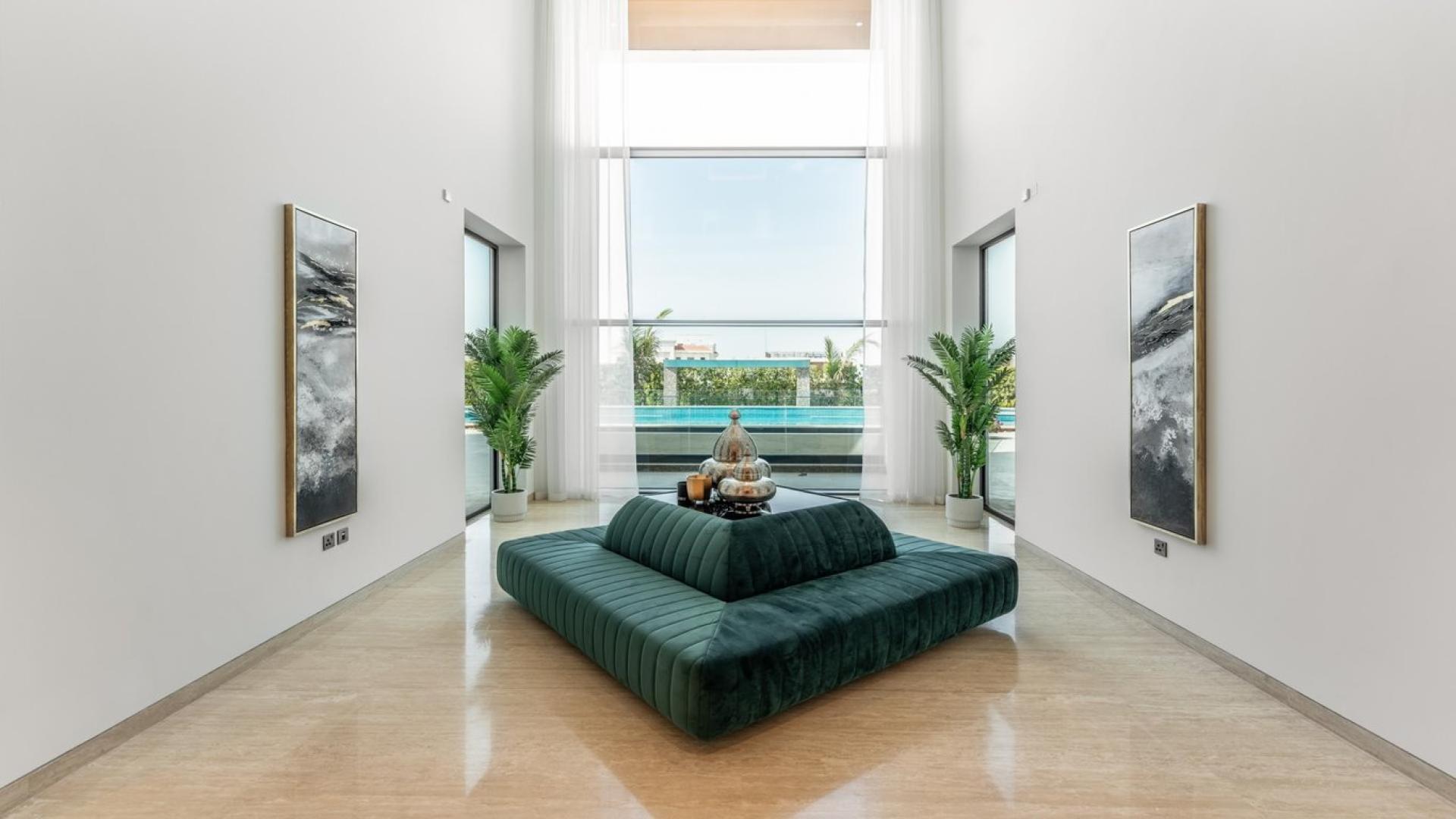 Luxurious living room in Dubai Hills Estate villa with modern decor and pool view