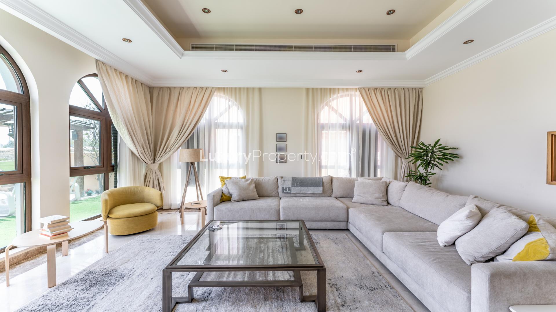 Luxurious villa living room with elegant decor, large windows, and pool view in Jumeirah