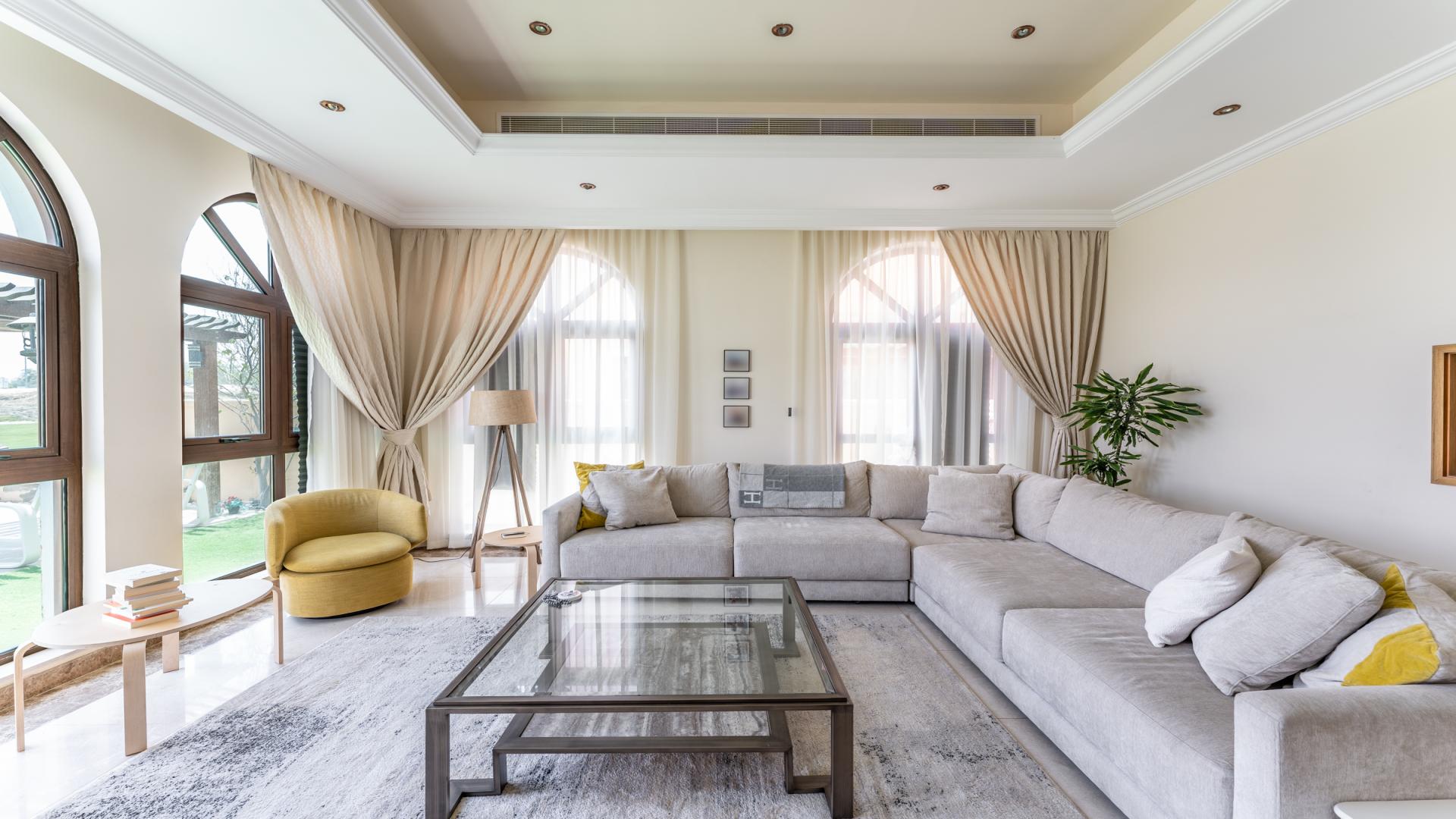 Luxurious villa living room with elegant decor, large windows, and pool view in Jumeirah