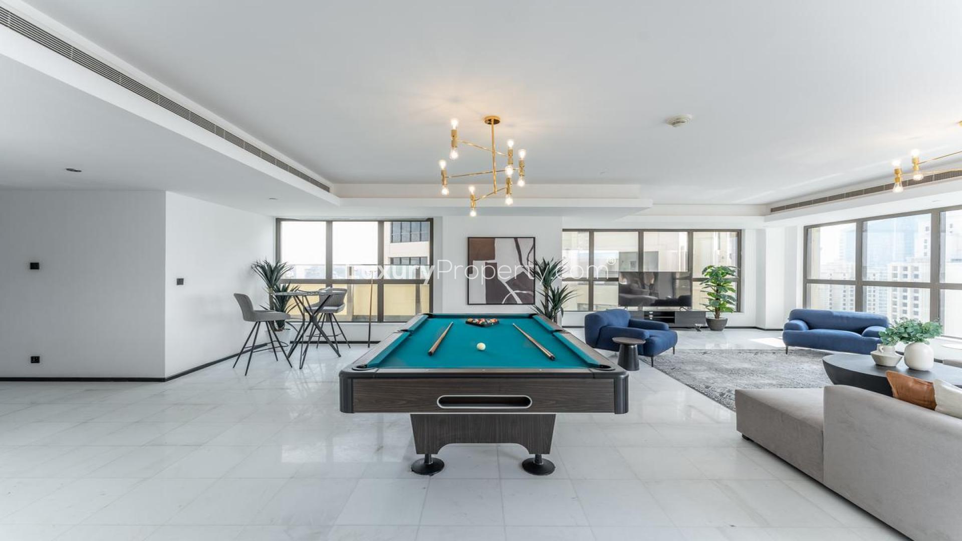 Furnished penthouse living room with large windows, modern decor, Jumeirah Beach Residence view