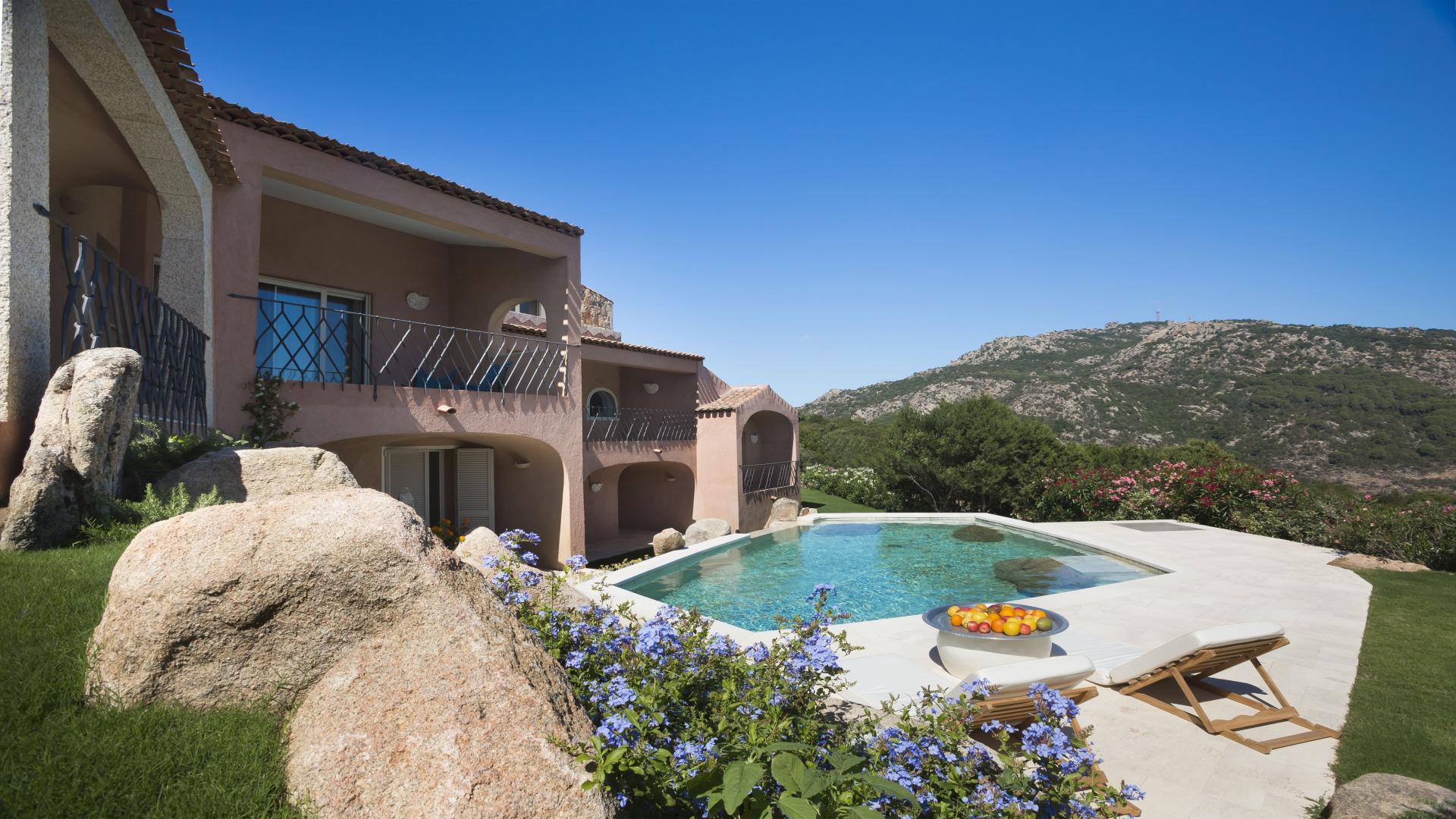 Luxury villa exterior with archway and greenery in Acquamarina, Costa Smeralda