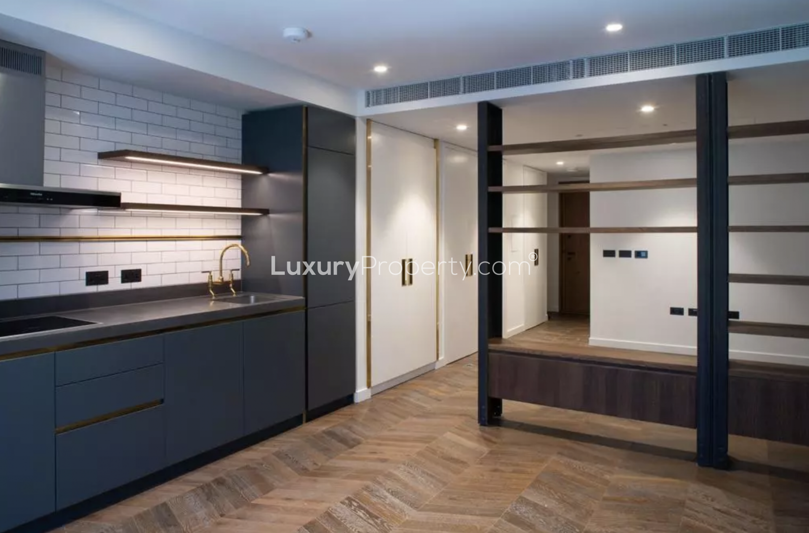 Modern kitchen in Battersea Power Station apartment, featuring sleek cabinetry and gold fixtures