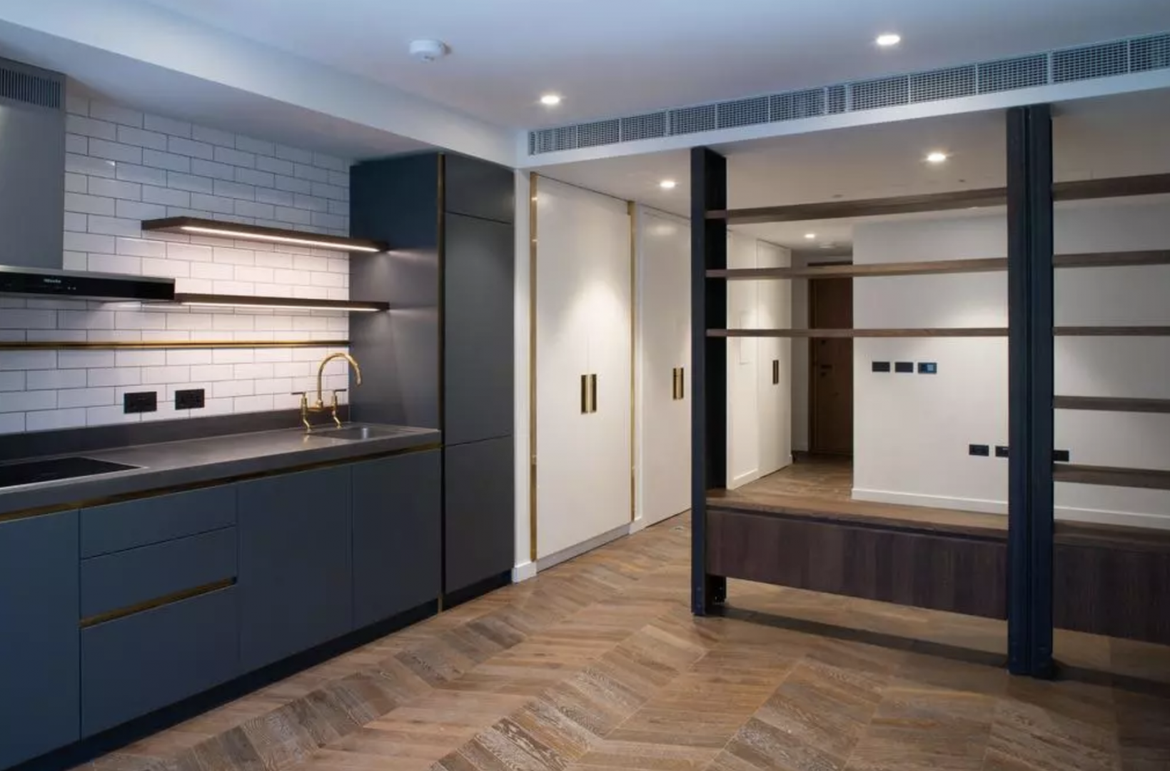Modern kitchen in Battersea Power Station apartment, featuring sleek cabinetry and gold fixtures