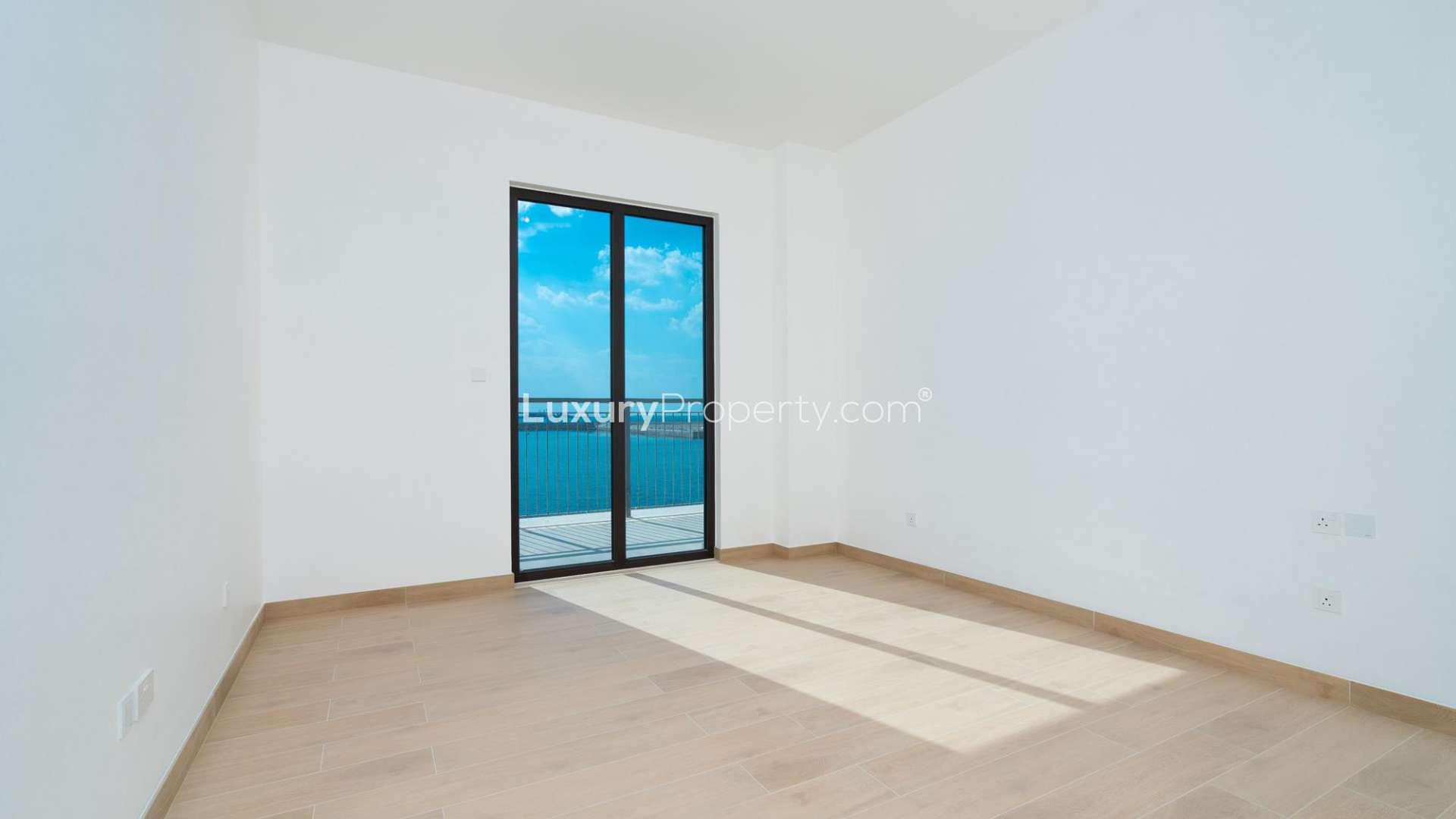 Empty apartment with large windows offering marina and Dubai skyline views in La Mer, Jumeirah