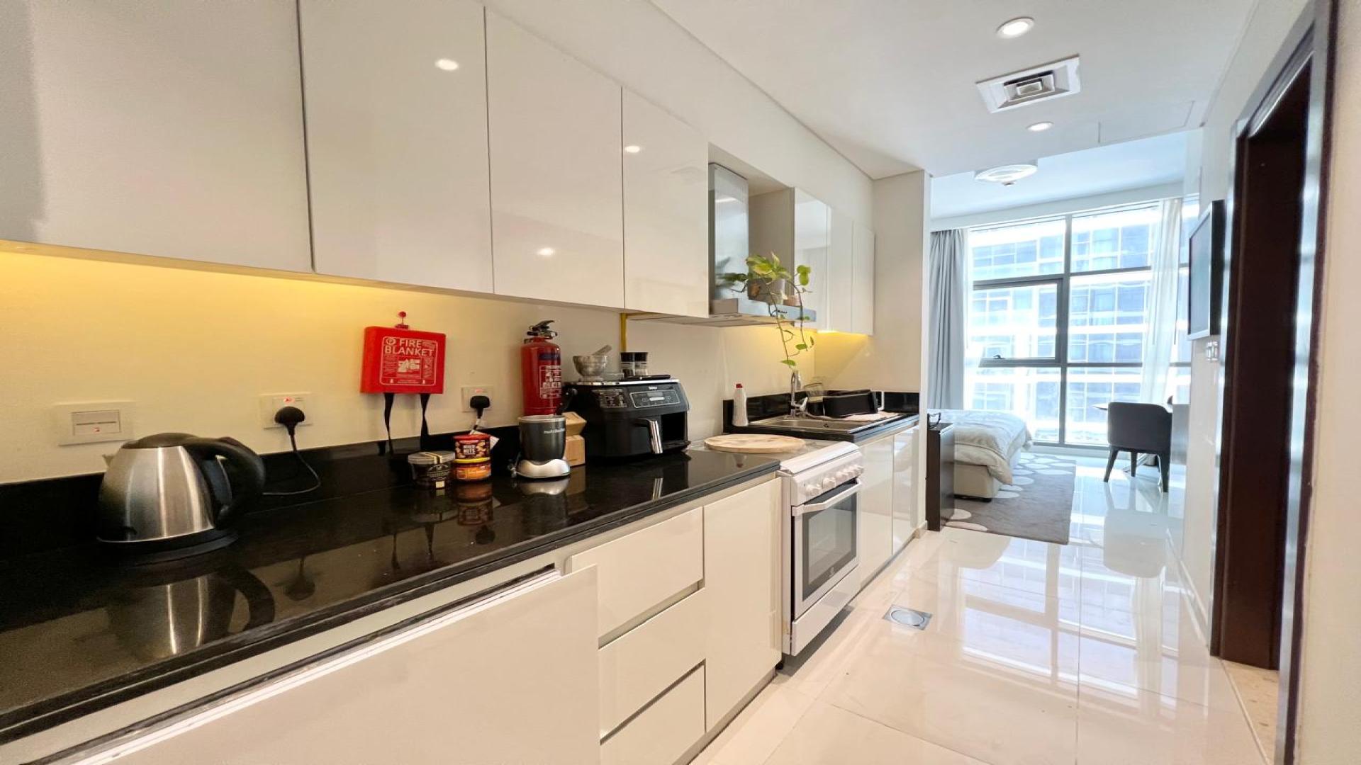 Fully furnished studio kitchen and living area in Damac Hills Golf Promenade apartment