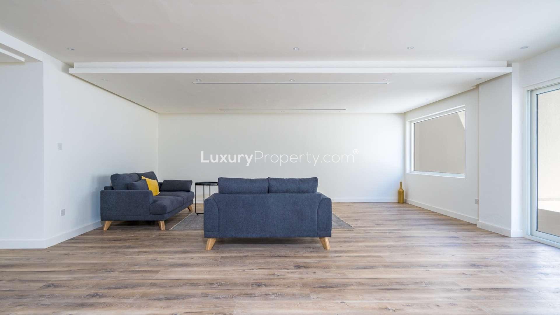 Modern living room in 5-bedroom penthouse, Jumeirah Lake Towers, with marina views and balcony