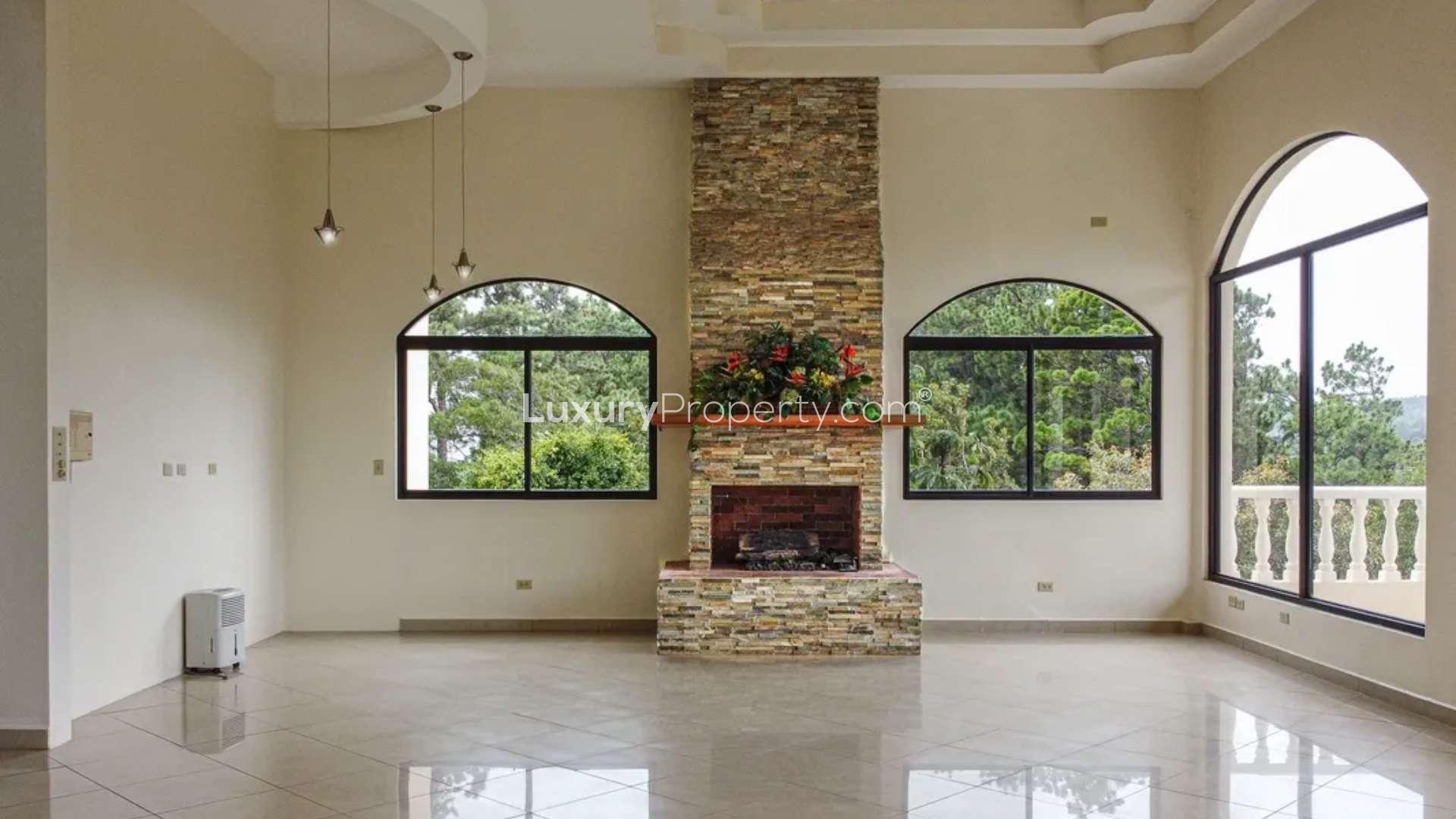 Spacious living room with large windows and fireplace in Jaramillo Mansion, Boquete, Panama
