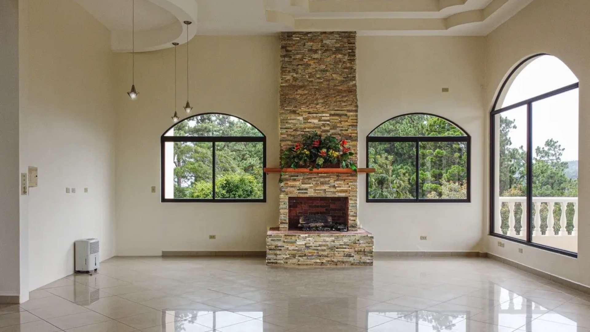 Spacious living room with large windows and fireplace in Jaramillo Mansion, Boquete, Panama