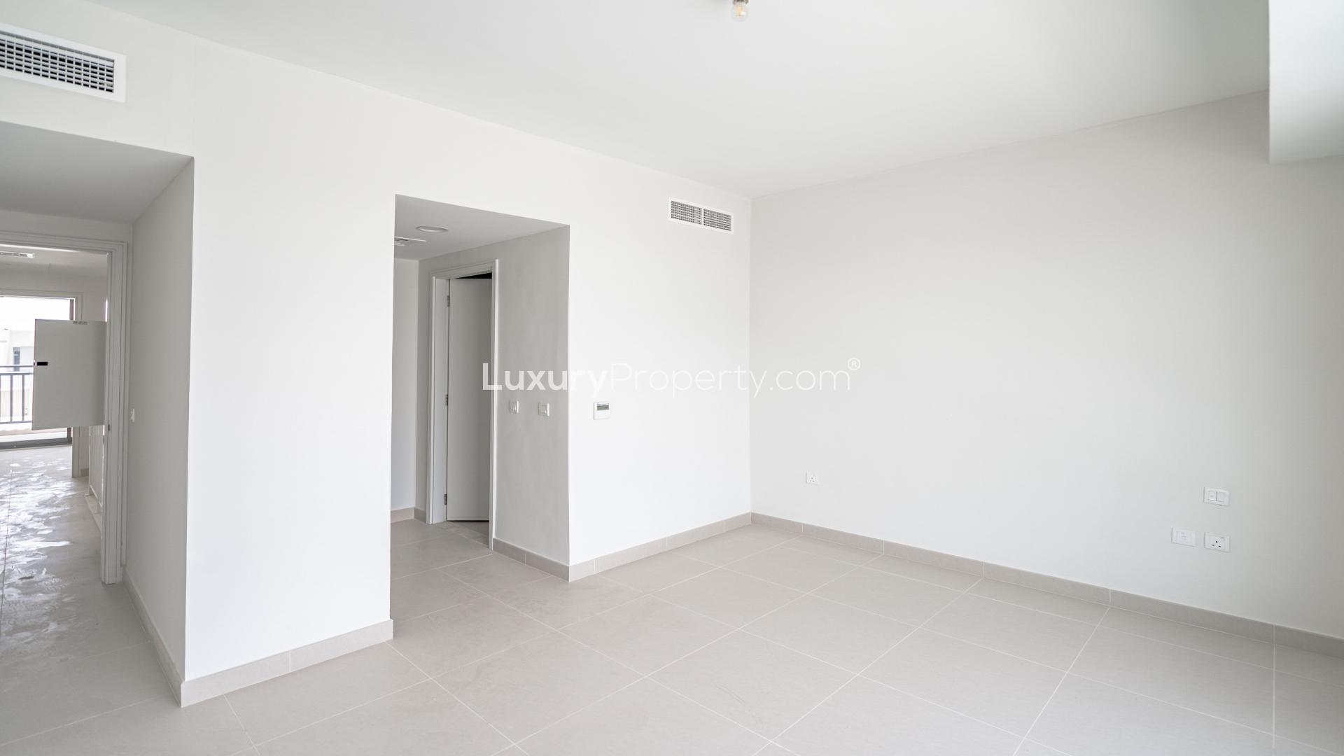 Empty room in townhouse, Maple at Dubai Hills Estate, with modern white interior and tile flooring
