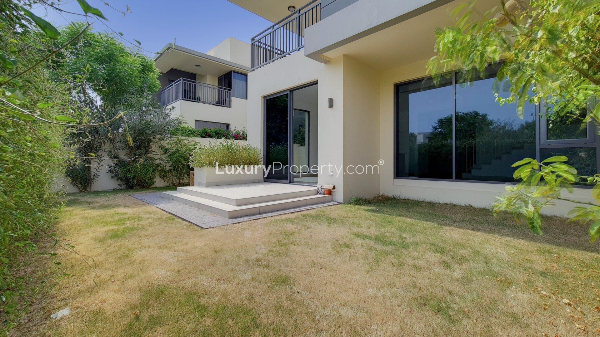 "Bright living area in 5-bedroom townhouse for rent, Maple 1, Dubai Hills Estate.",Exterior view of Maple 1 townhouse garden in Dubai Hills Estate, lush greenery and patio