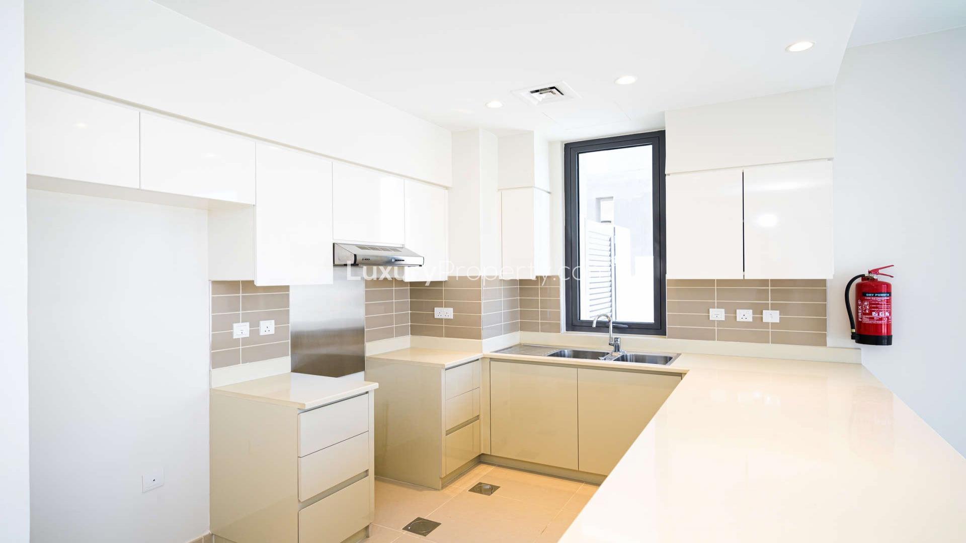 Modern kitchen in townhouse at Maple, Dubai Hills Estate, featuring sleek cabinetry and countertops
