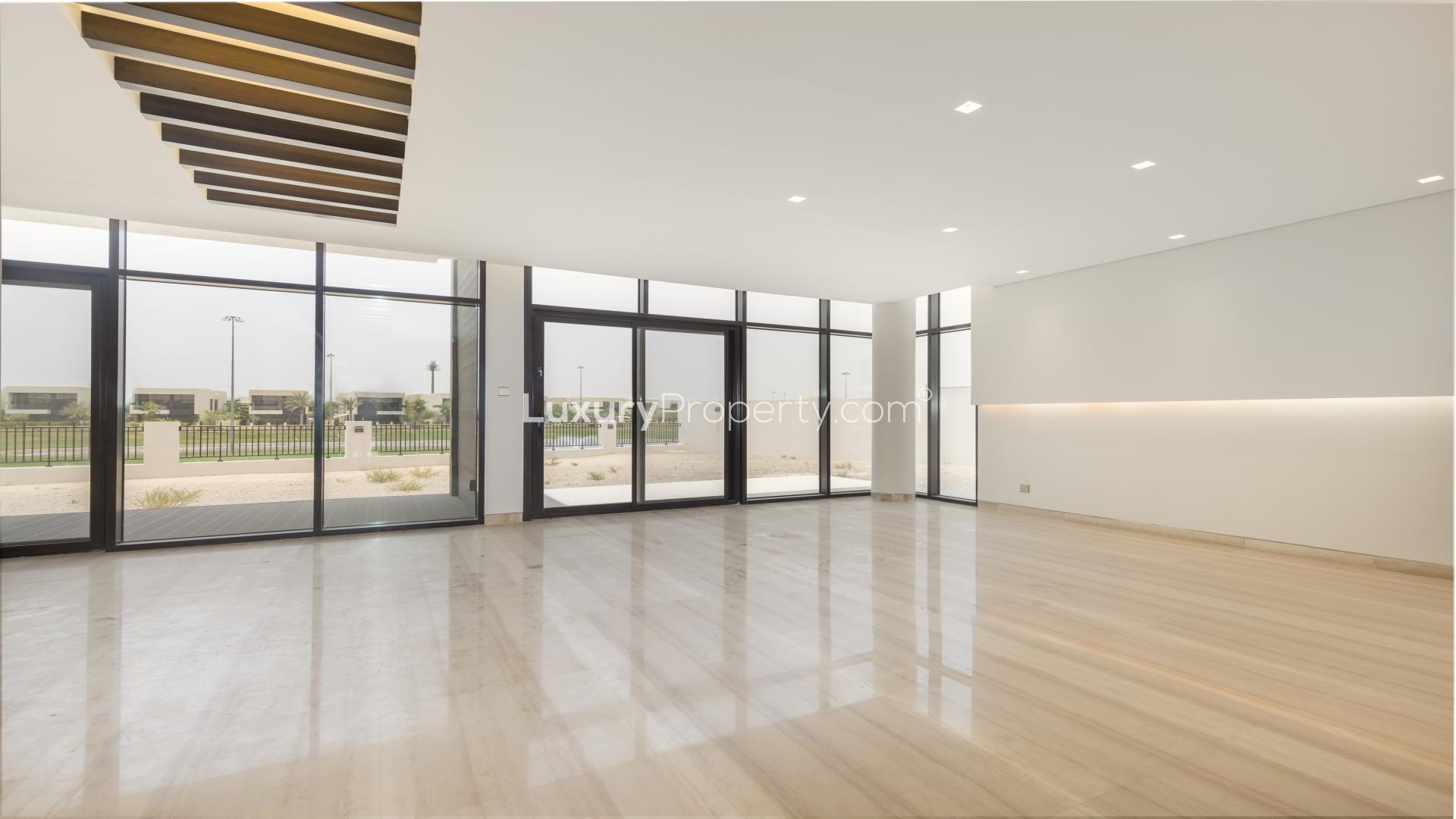 "Balcony view of golf course from luxury villa in Trevi, Damac Hills for rent.",Spacious living room with large windows, golf course view in Damac Hills Trevi villa