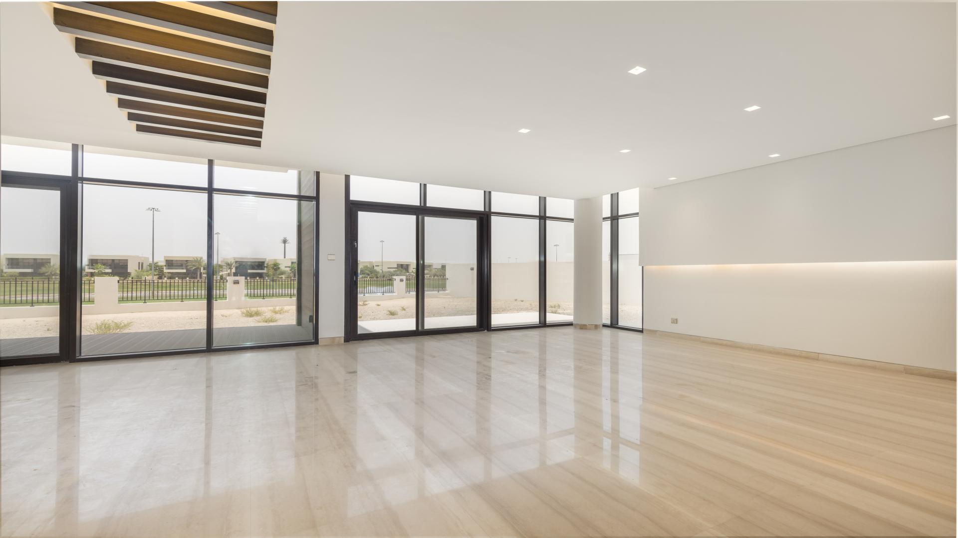 "Balcony view of golf course from luxury villa in Trevi, Damac Hills for rent.",Spacious living room with large windows, golf course view in Damac Hills Trevi villa