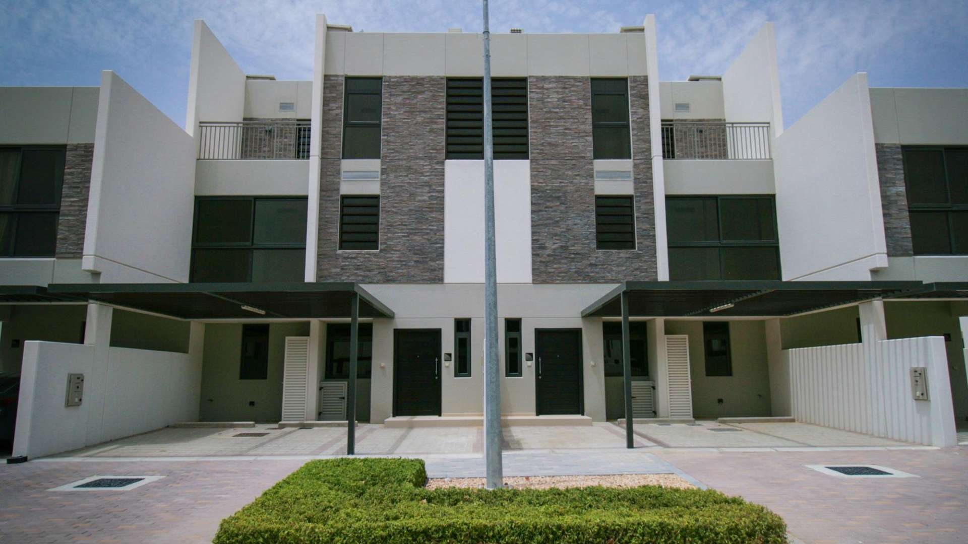 Elegant townhouse exterior in Claret, Damac Hills 2, featuring modern architecture and driveway