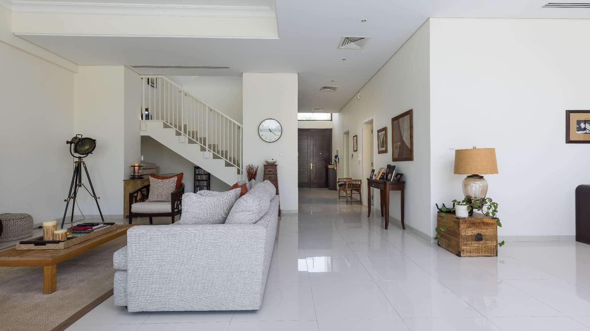 Luxury living room in 5-bedroom villa, Rochester, Damac Hills, with modern decor and staircase