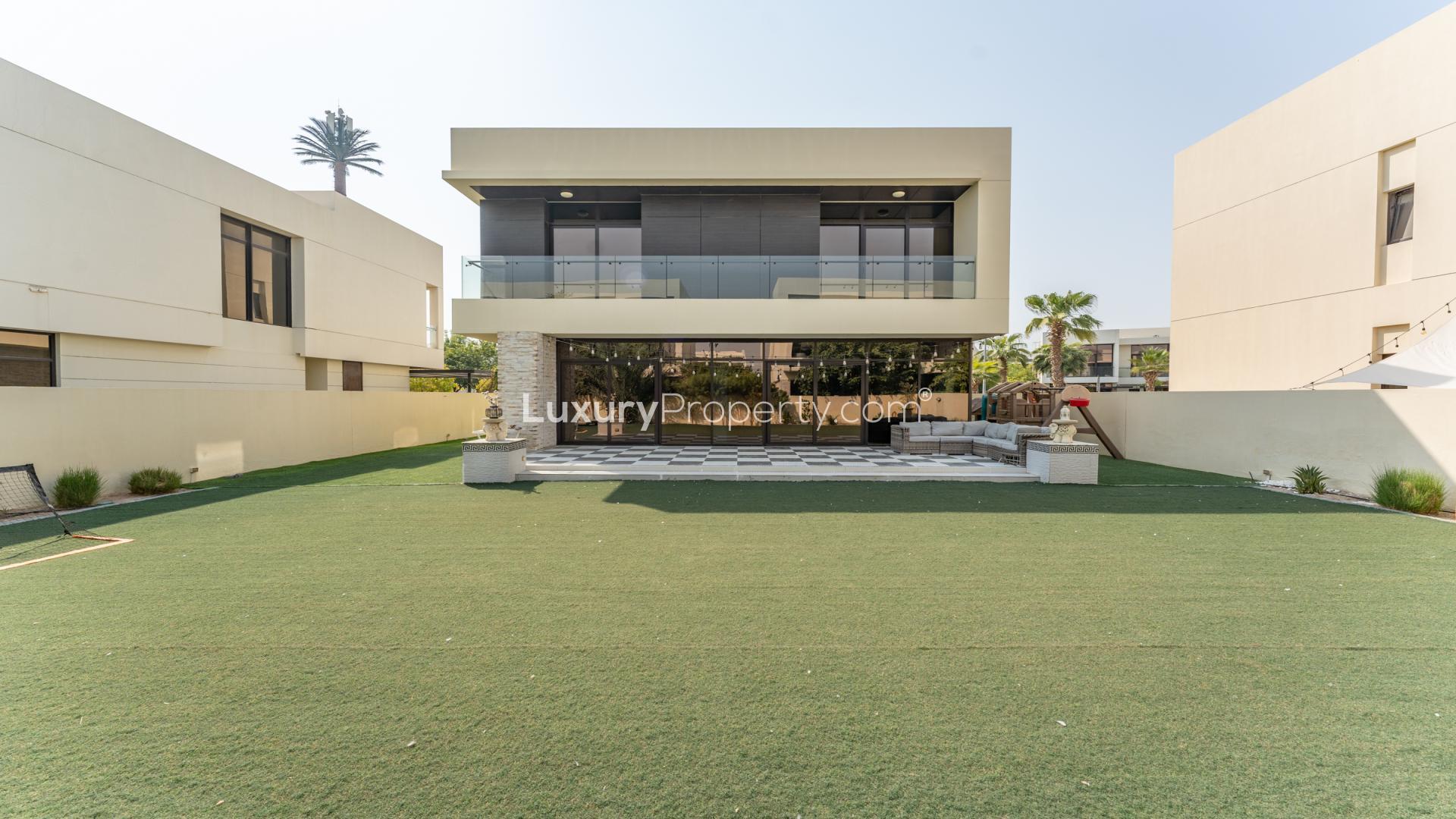 Partially furnished villa interior with modern dining area and garden view in Damac Hills