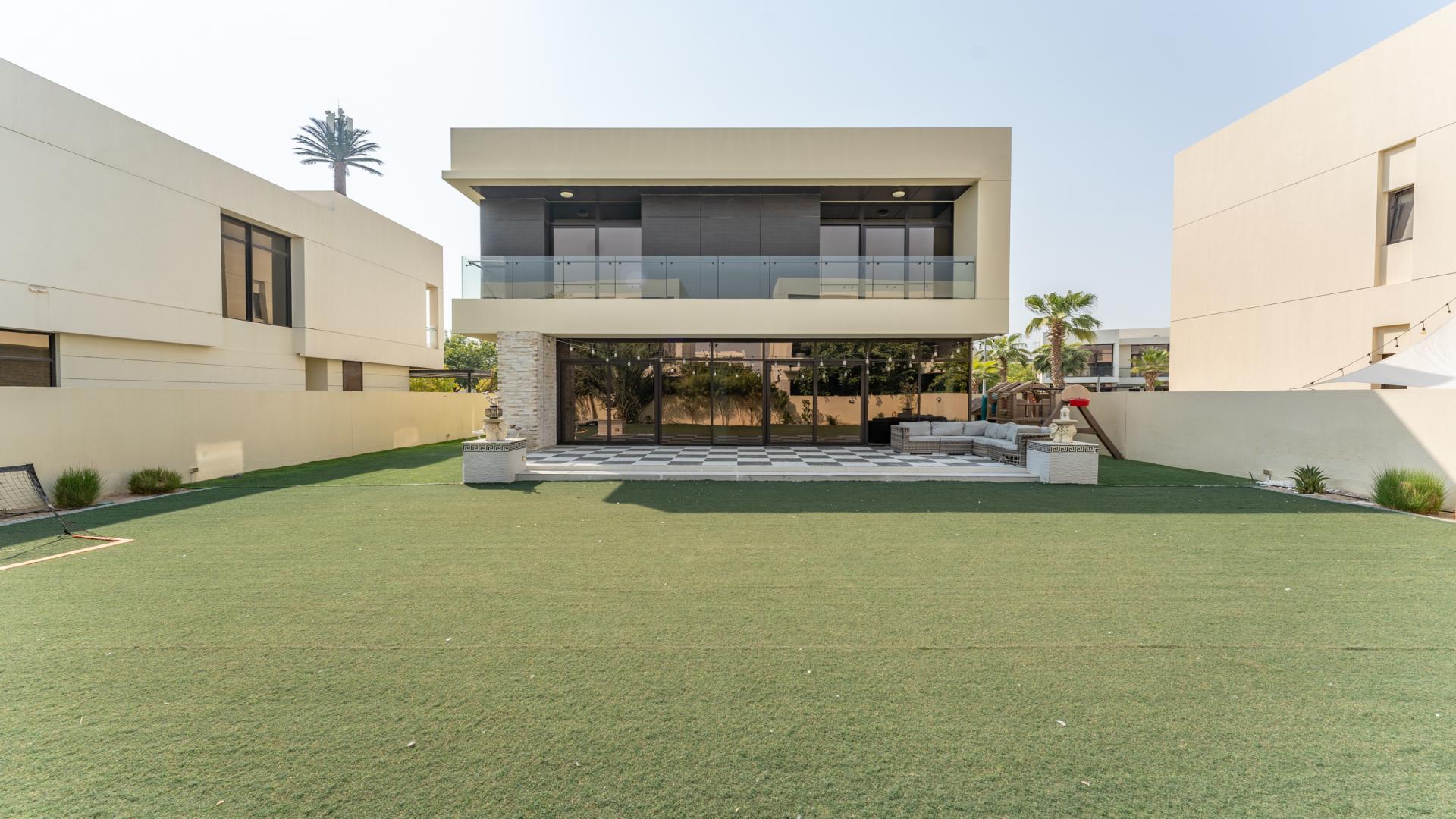 Partially furnished villa interior with modern dining area and garden view in Damac Hills