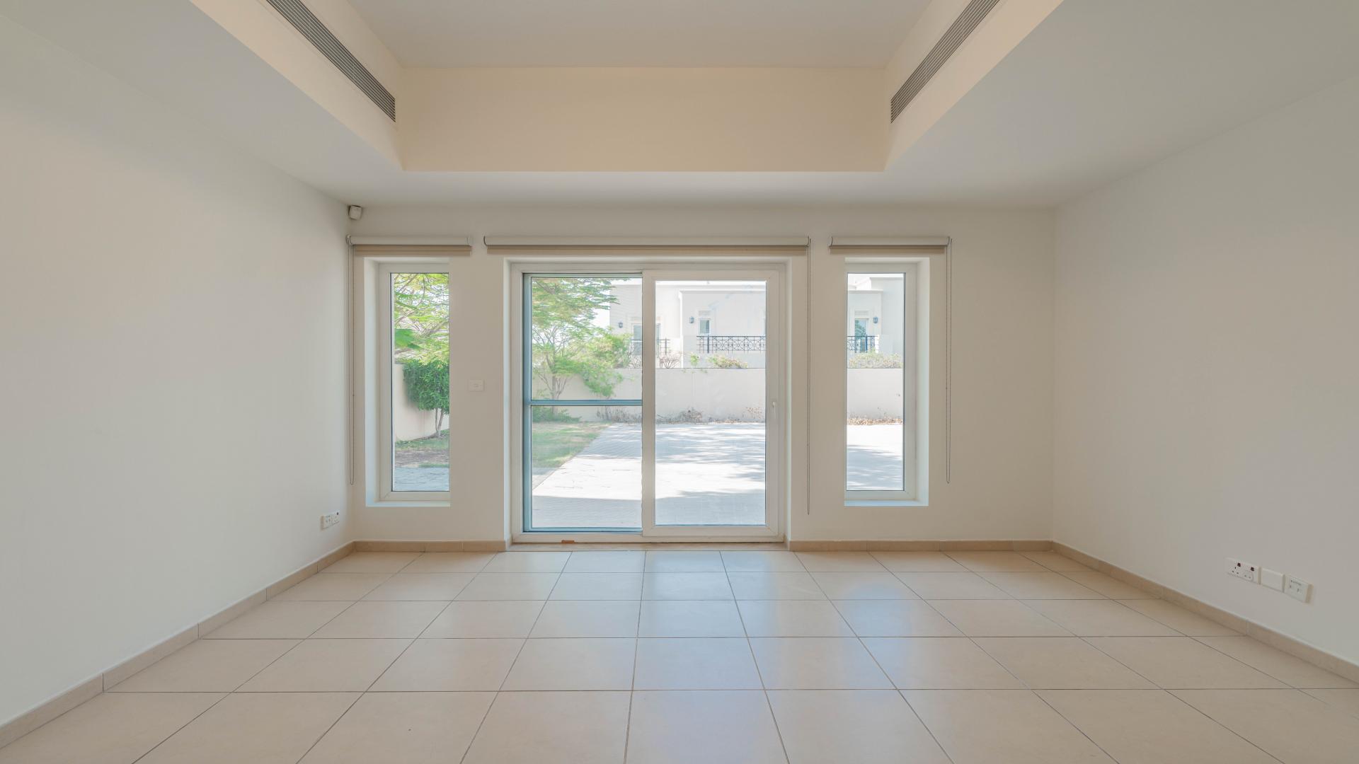 Bright living room with large windows in Arabian Ranches villa, Al Mahra community