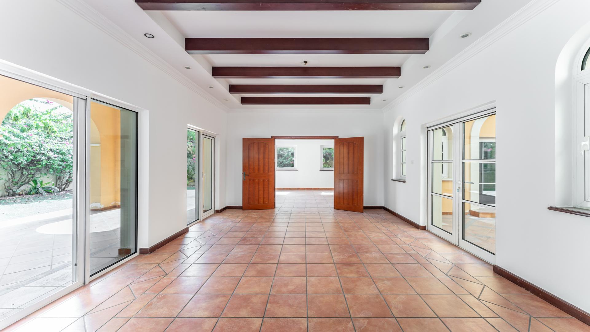 "Spacious 5-bedroom villa with private pool in The Aldea, The Villa community for rent.",Spacious villa interior with tiled floors, wooden beams, and garden view in The Aldea