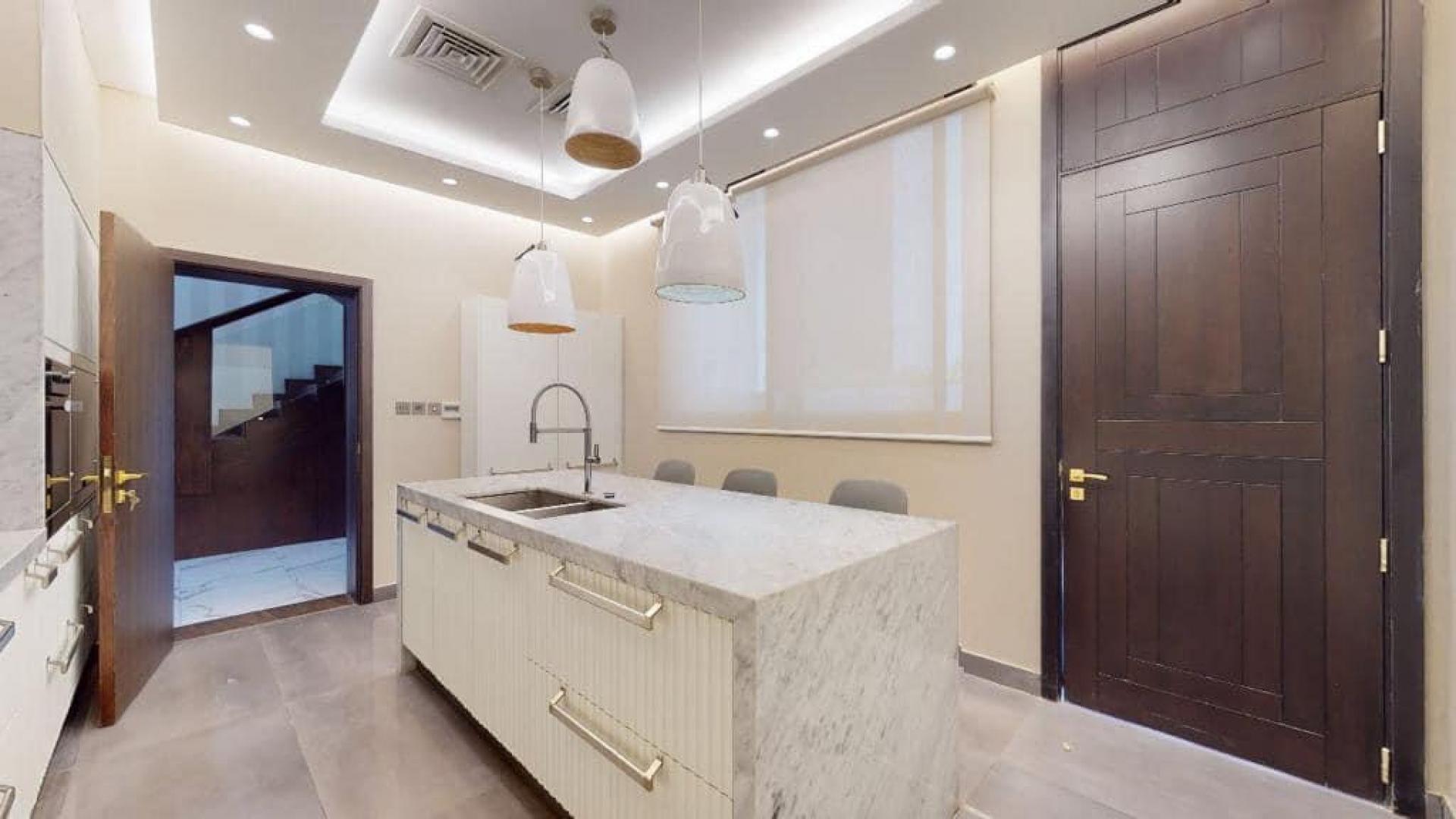 Modern kitchen with marble island in upgraded Damac Hills villa, Brookfield community