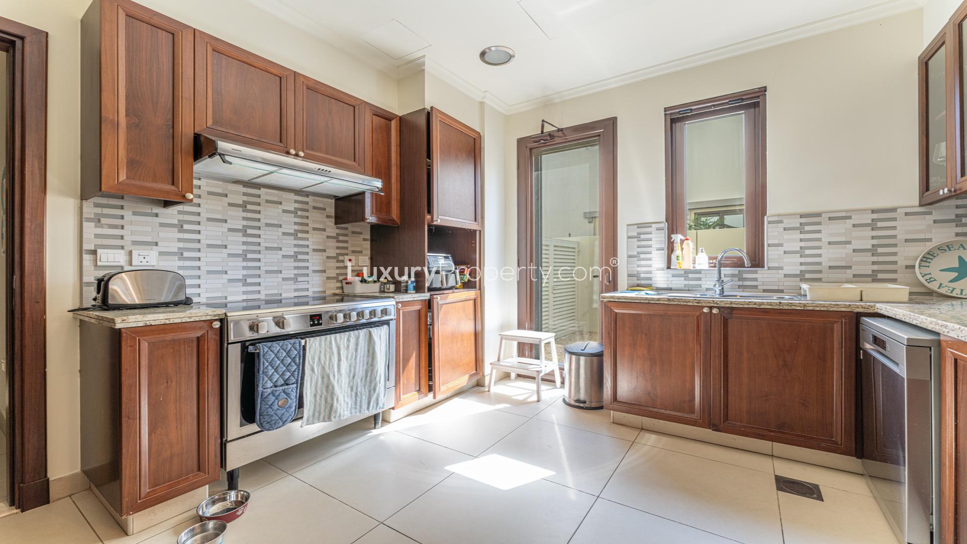 Elegant kitchen in 5-bedroom villa, Arabian Ranches 2, featuring modern appliances and wooden cabinets