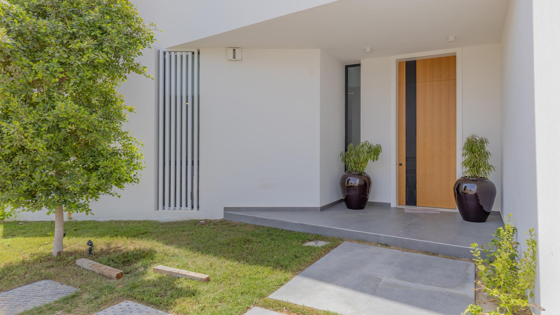 Contemporary villa living room with yellow seating, large windows in Al Barari, Chorisia 1