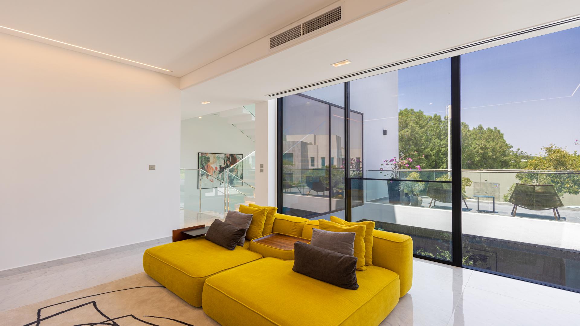 Outdoor patio of Chorisia 1 Villa, Al Barari, with modern seating and garden view